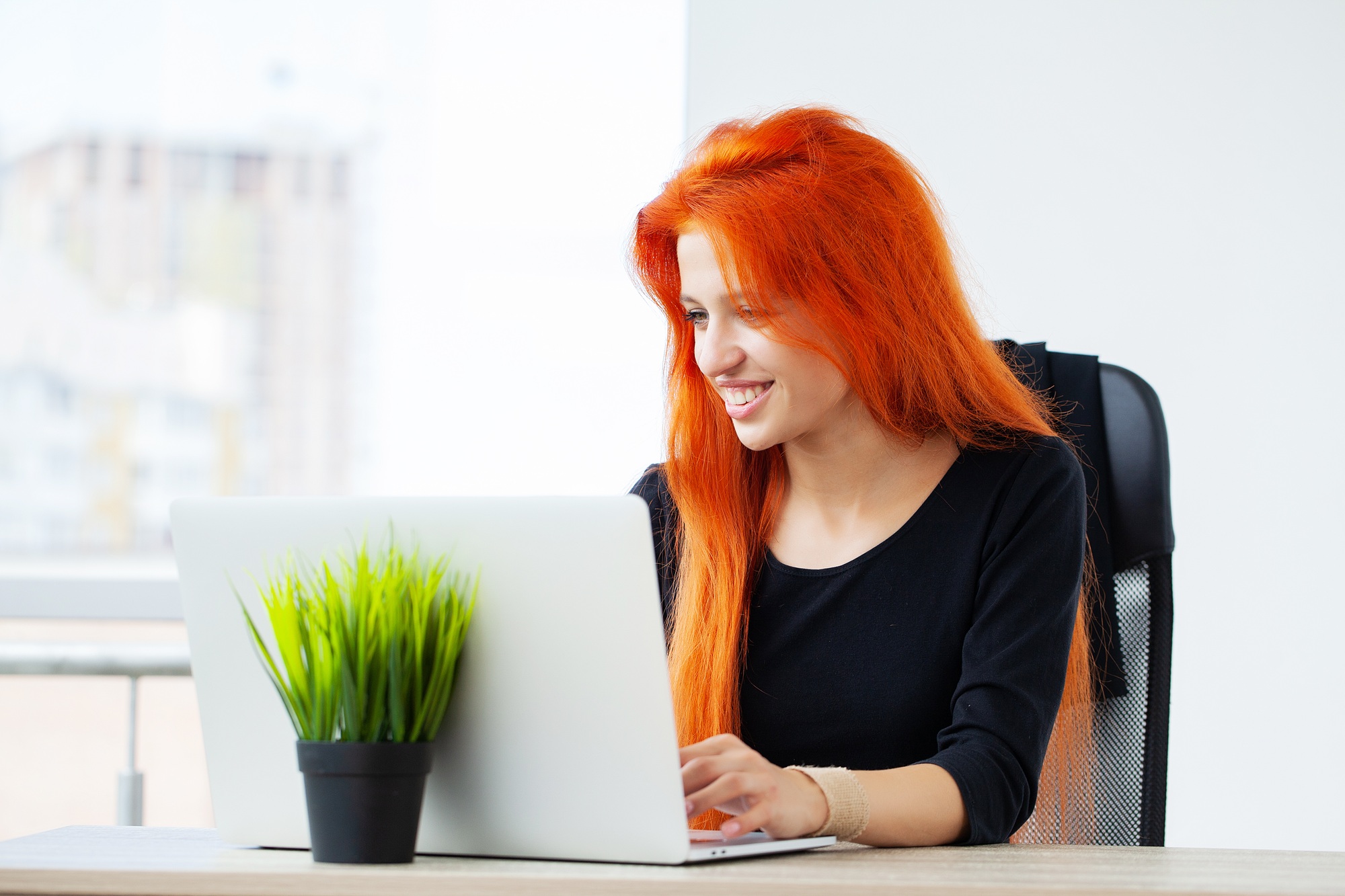 Cheerful red haired female economist develops financial startup project