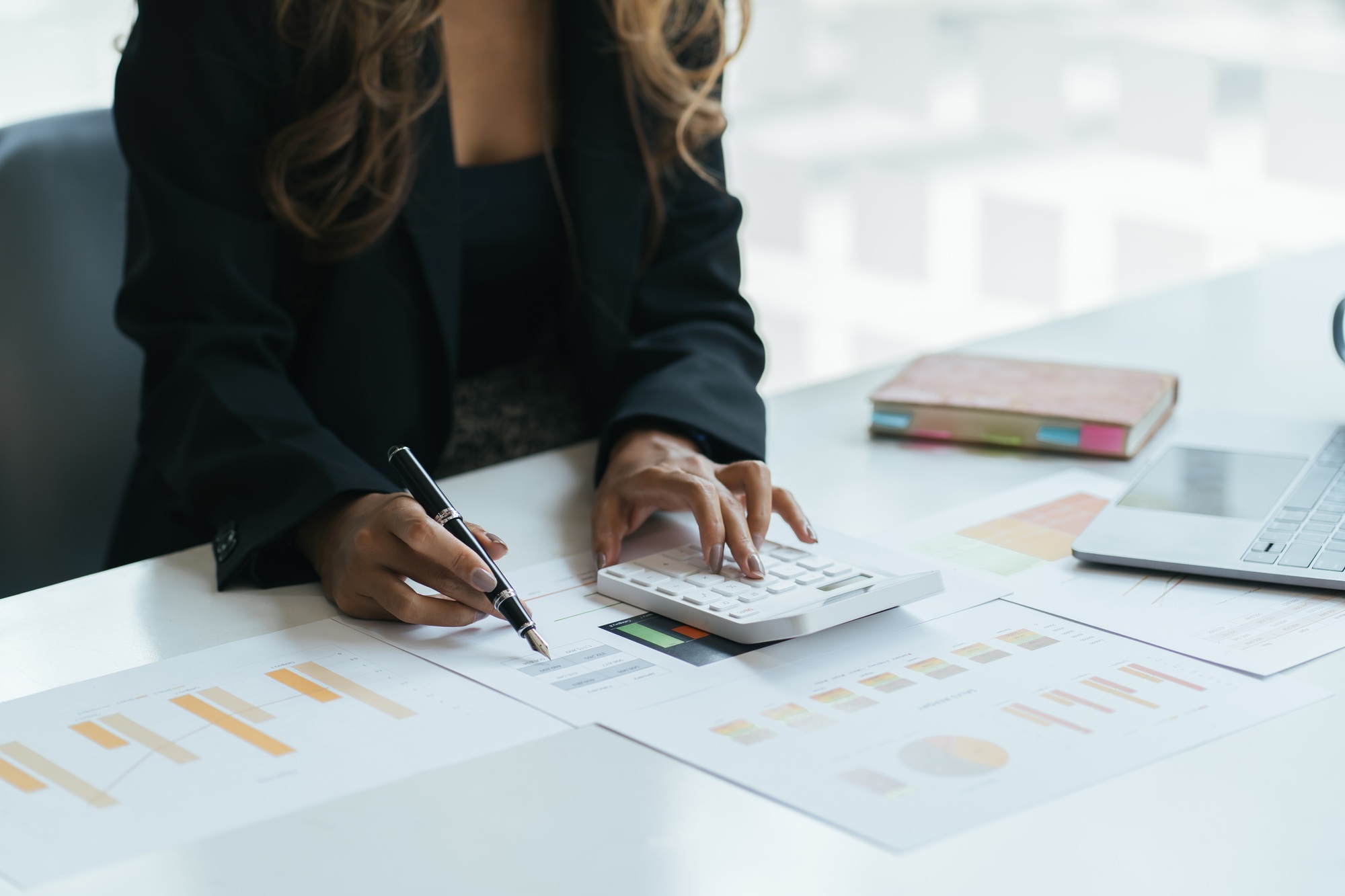 Close up young business woman reviewing project economic statistics, calculating sales or financial