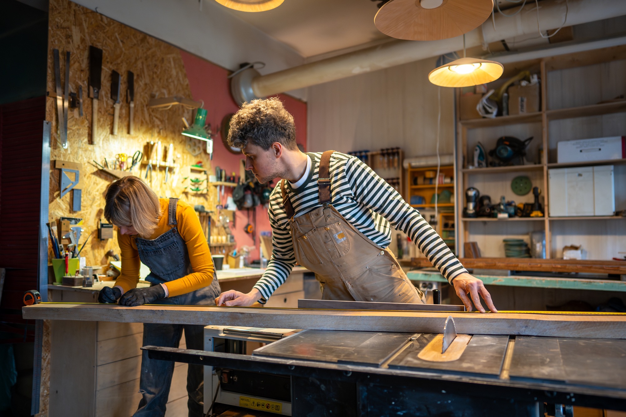 Craftsmen work in carpentry workshop. Professionals working with wood, taking measurements