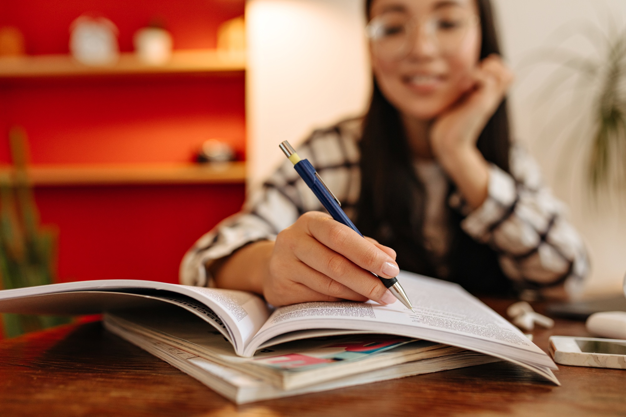 Dark-haired woman underlines important lines in book during training