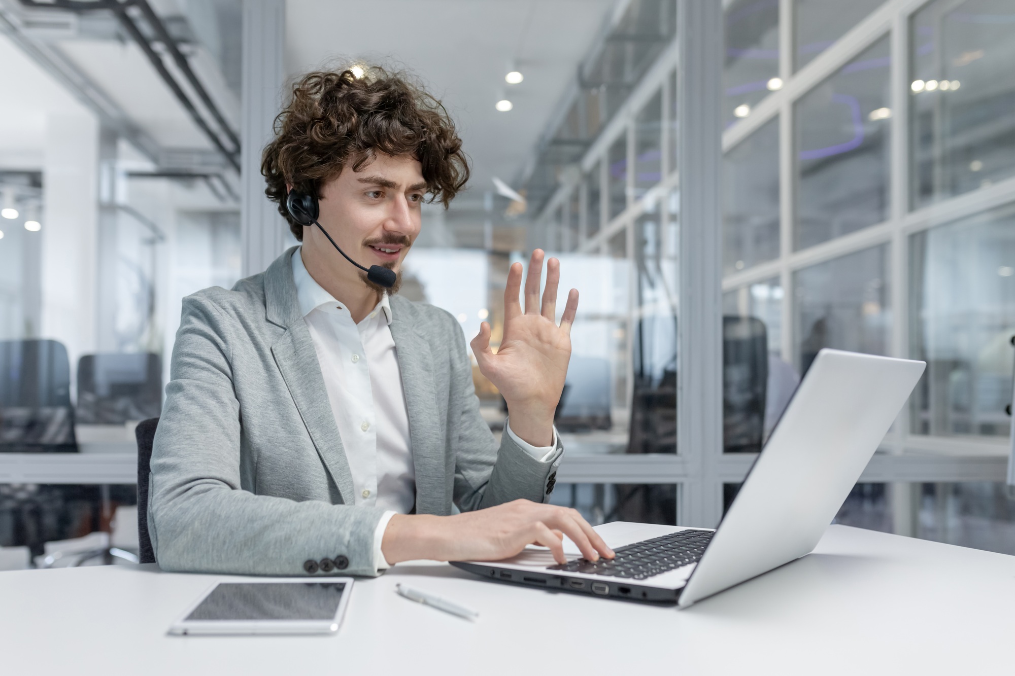 Experienced young businessman engaged in video call conversation at office desk