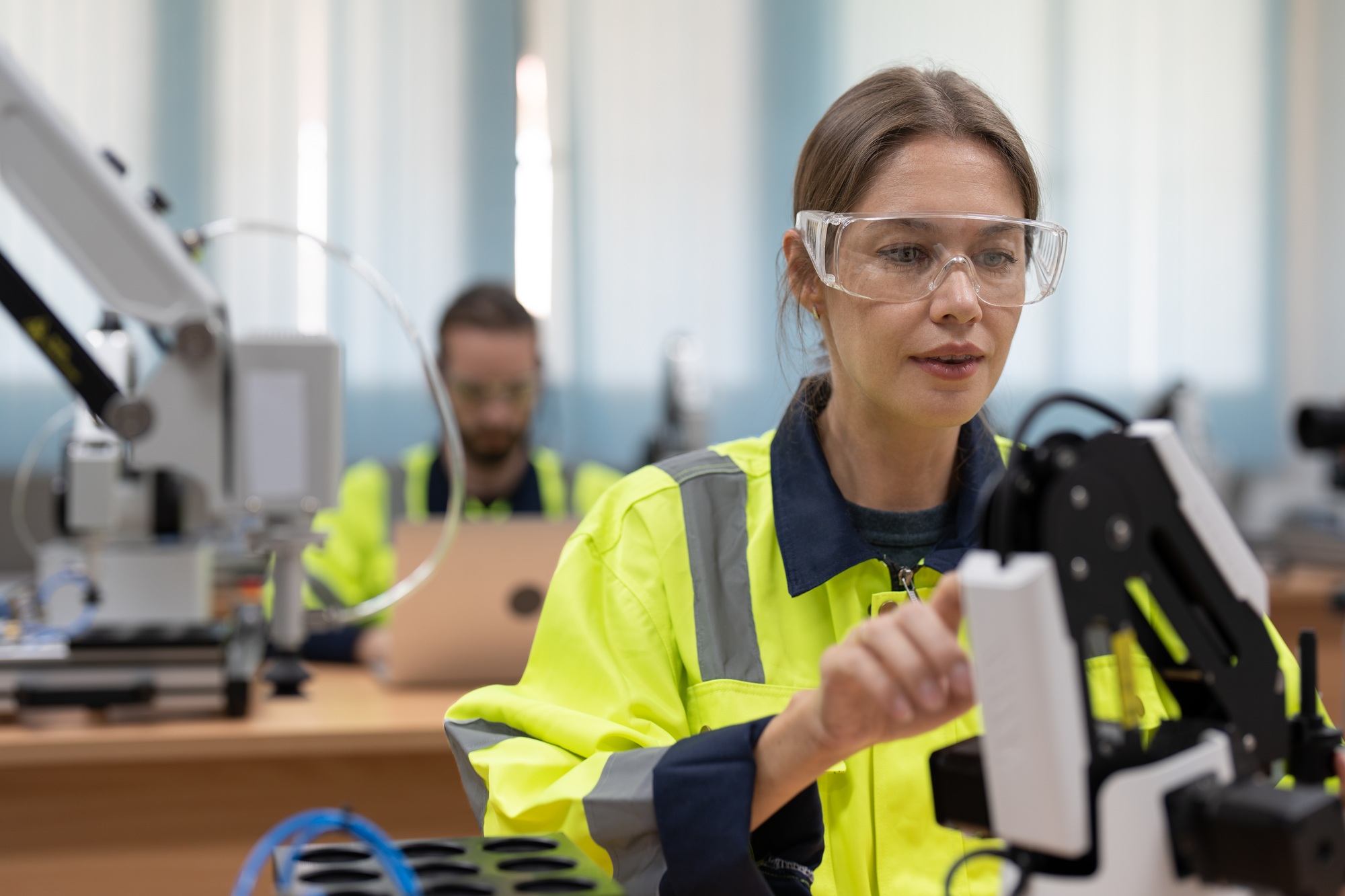 Female engineer training programmable and design AI robot arm simulation in academy robotics