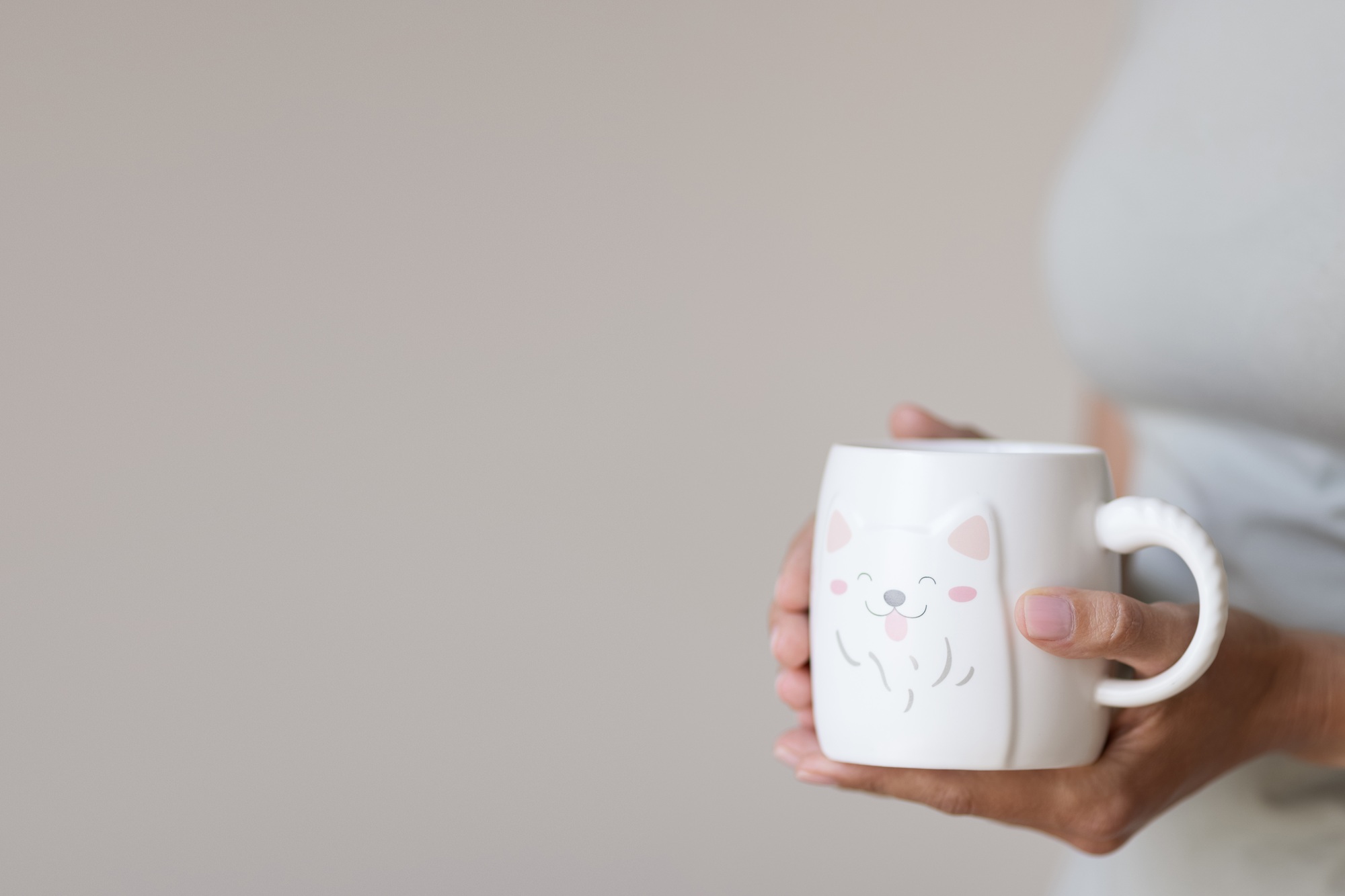 Female Hands holding coffee cup. mockup for creative design branding on beige background with copy
