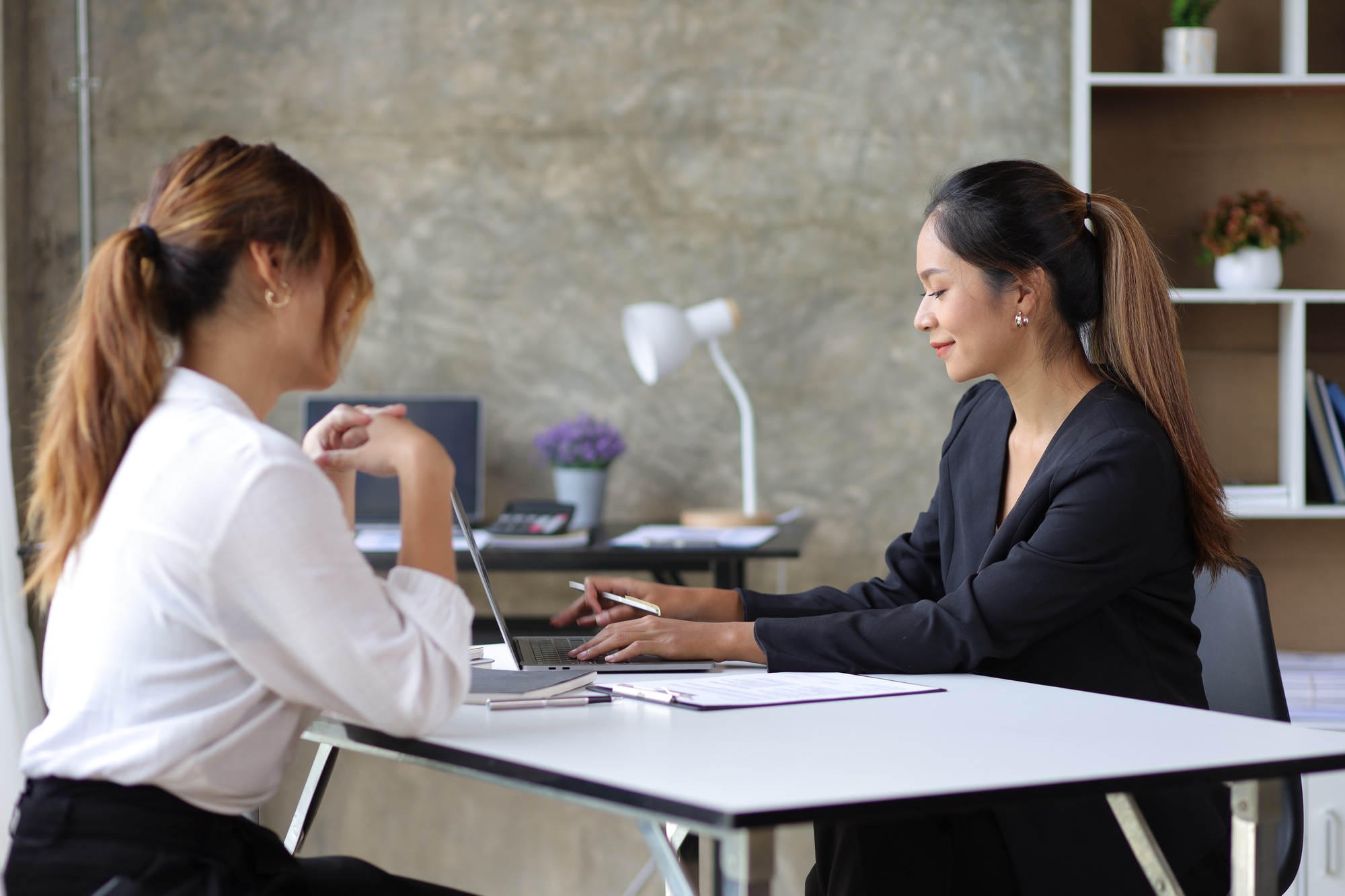 Female manager in office discussing and interviewing job applicant for new employees.
