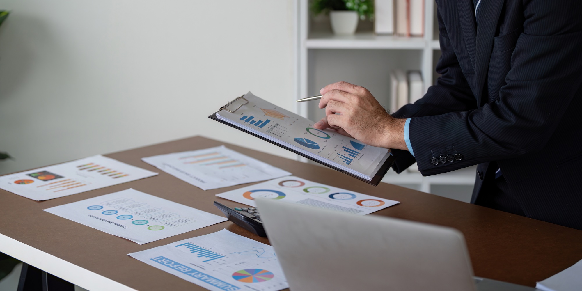 Focused Businessman Reviewing Financial Data on Clipboard