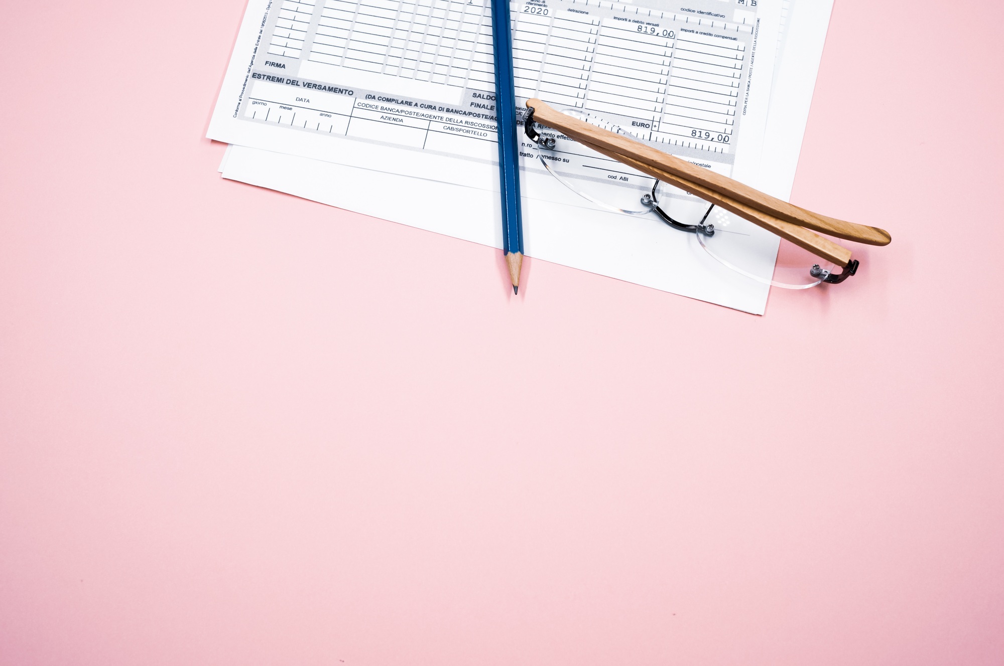Form paper and a pencil on a pink background