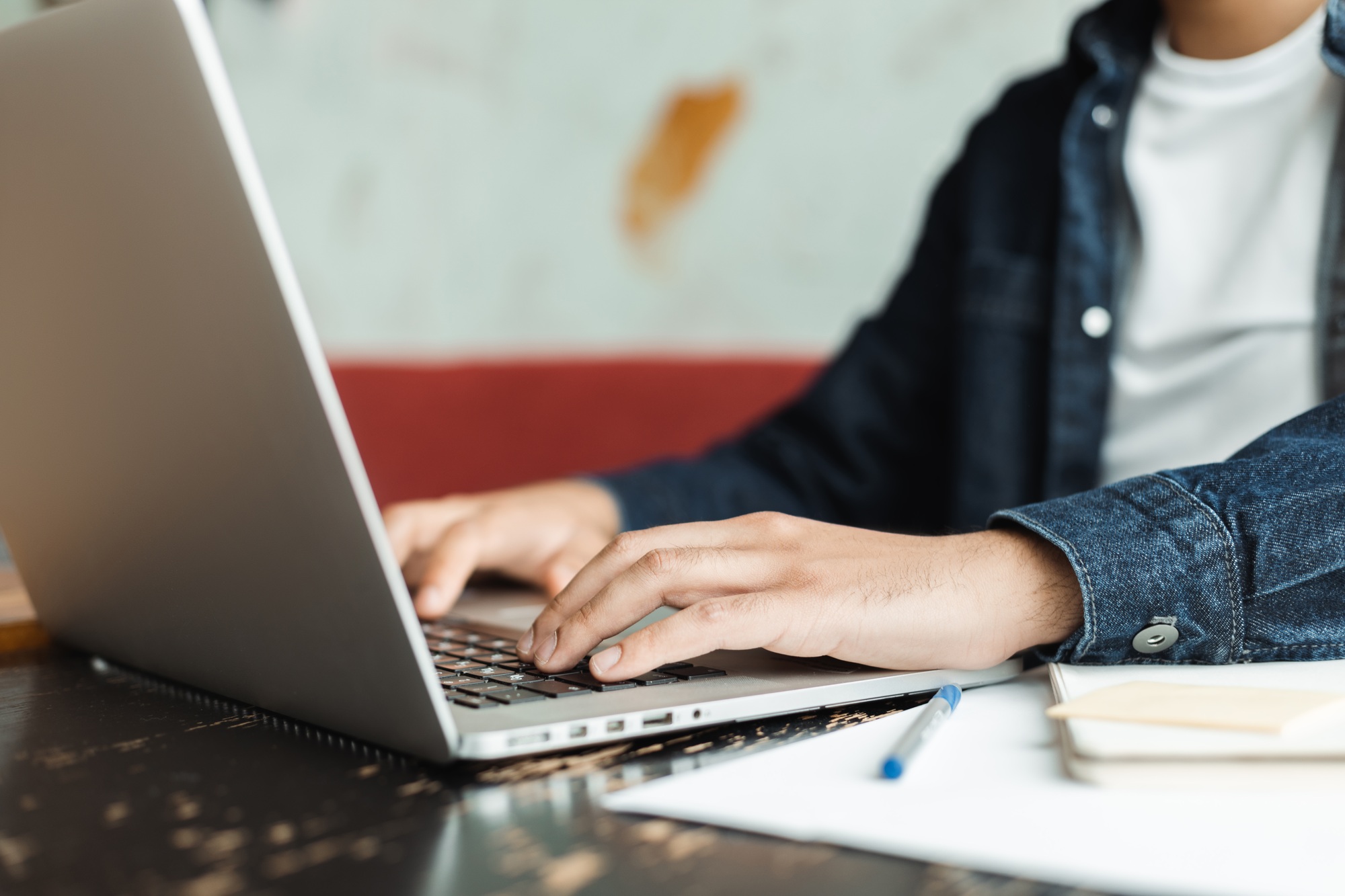 Freelancer working remotely from coworking space typing on laptop keyboard