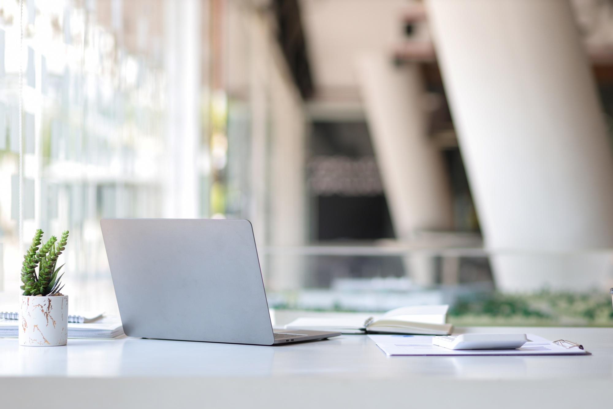 Laptop on a desk in an open financial office.