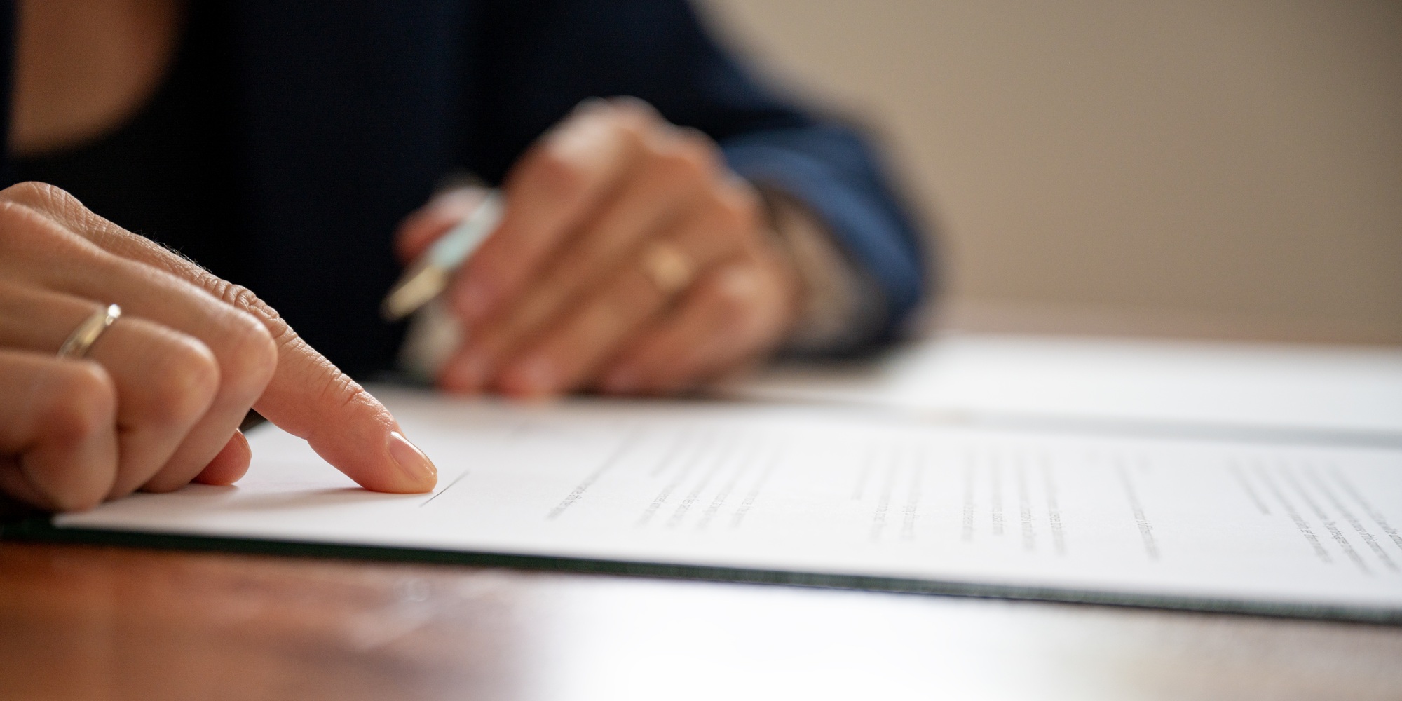 Lawyer pointing to a signature line at the bottom of document