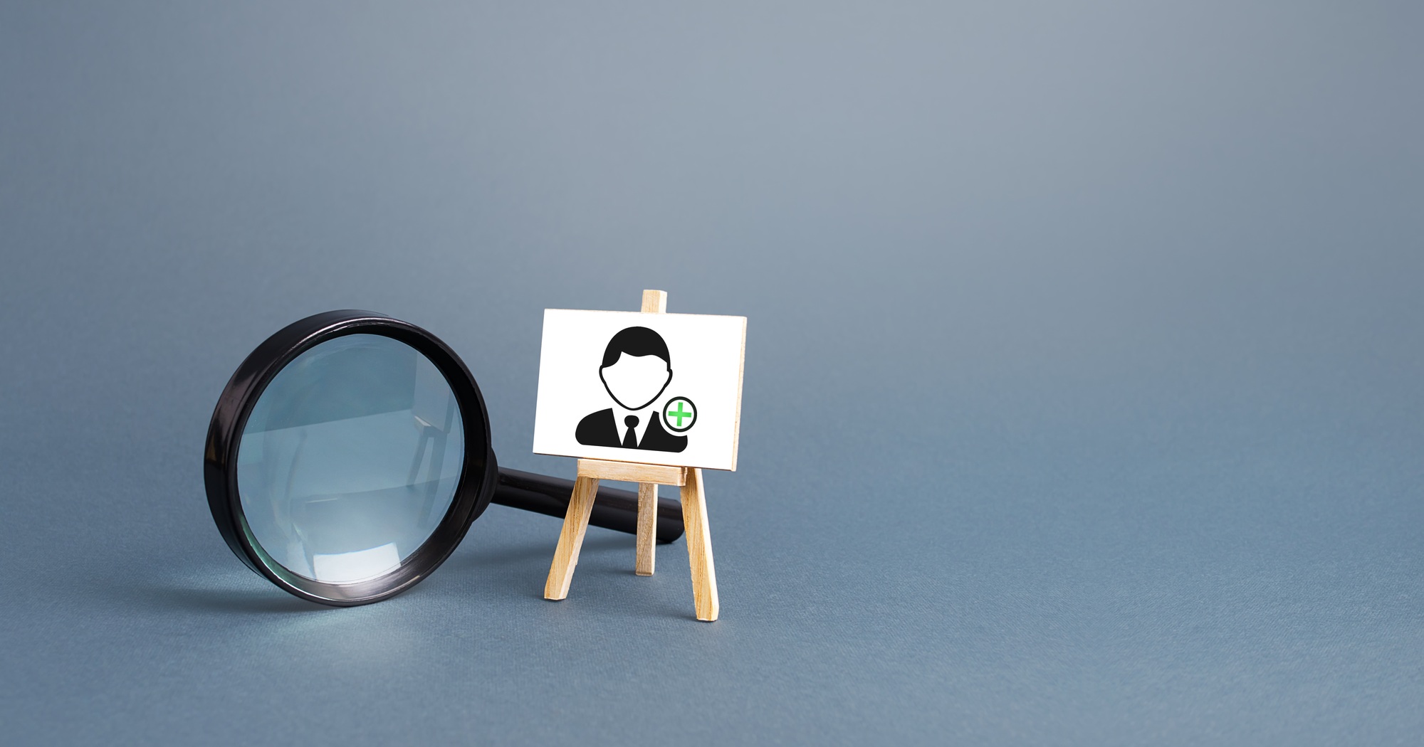 Magnifying glass and an easel with a new hired employee.