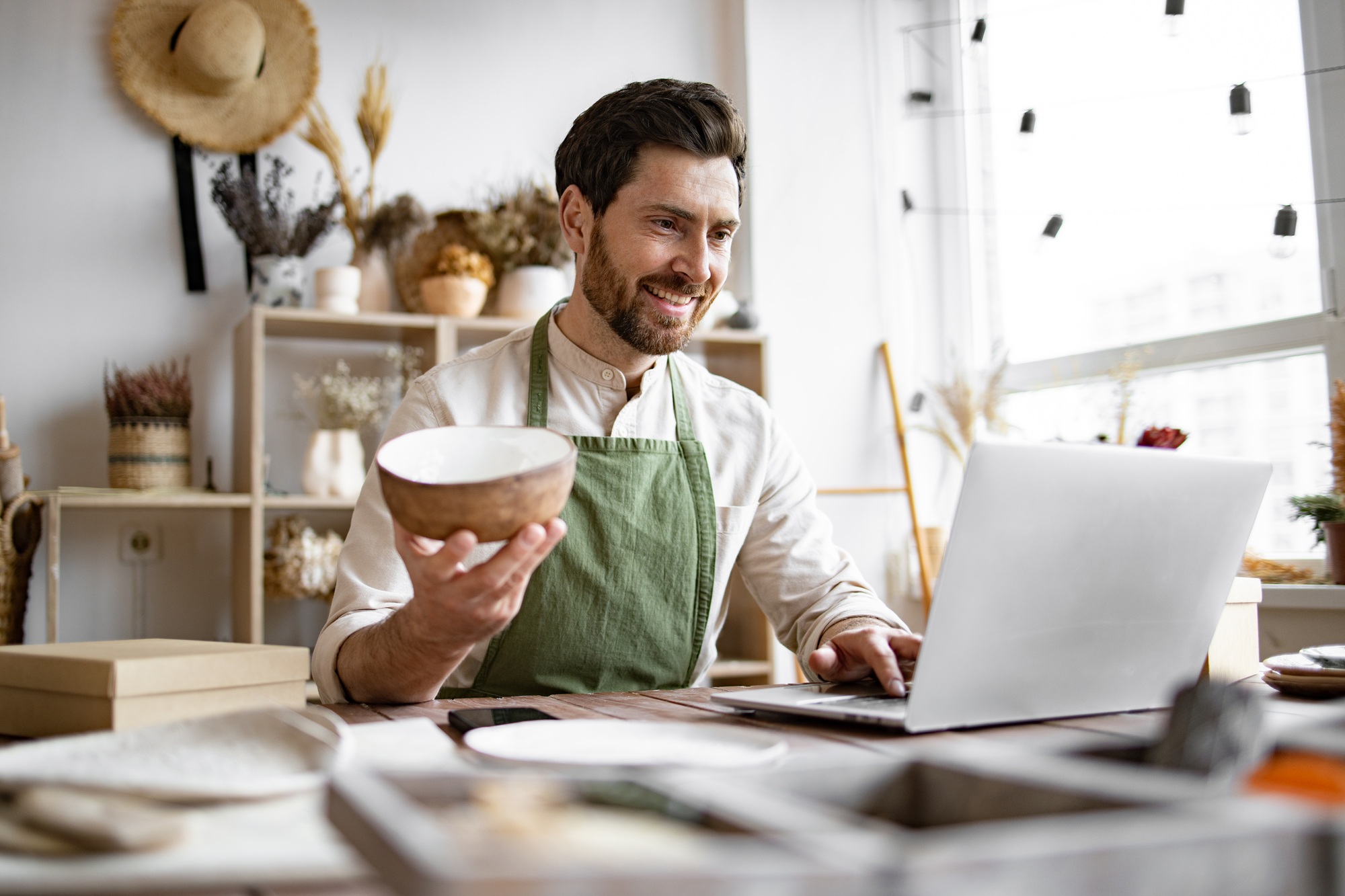 Male potter engaged in e-commerce selling handmade clay products