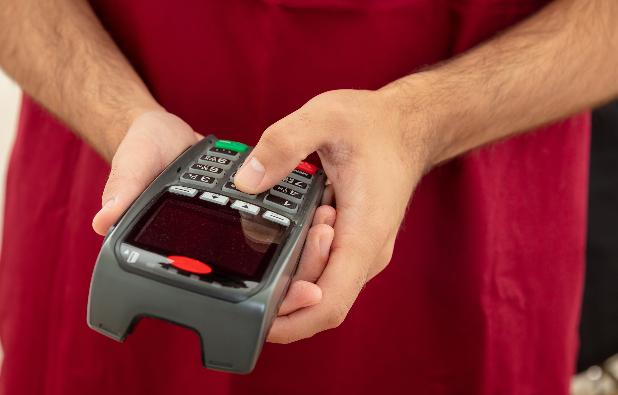Man typing on a POS terminal, payment with credit card. Banking, shopping concept.
