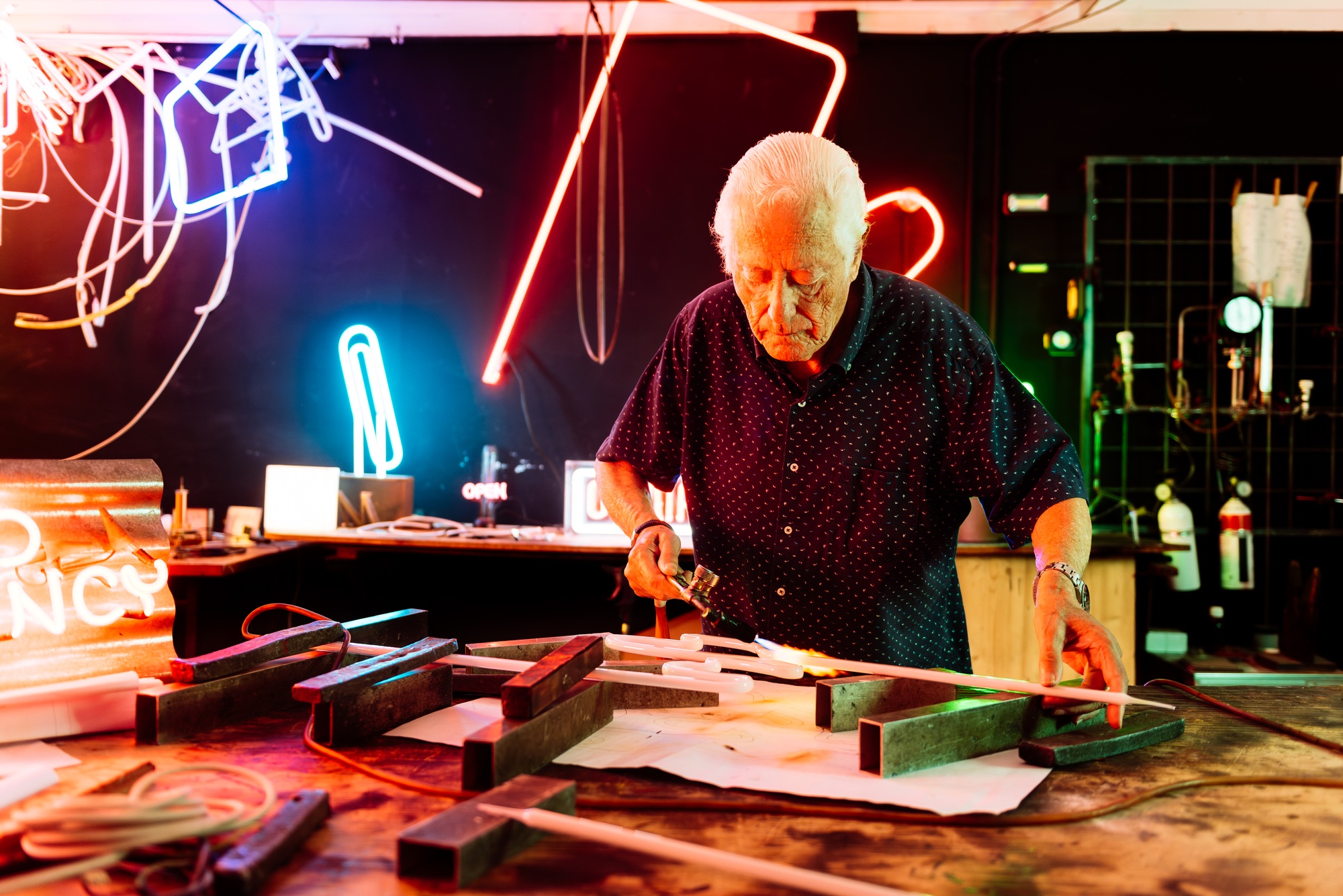 Master Neon Sign Artisan Working in His Shop