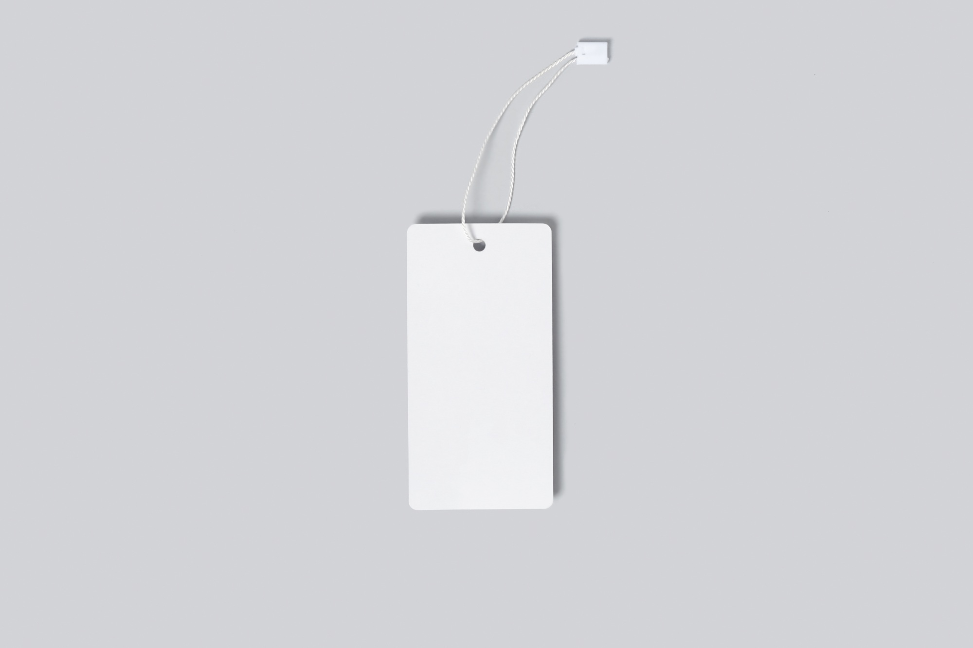 Mockup of a vertical empty white tag for clothes on a gray background. Template for your logo design