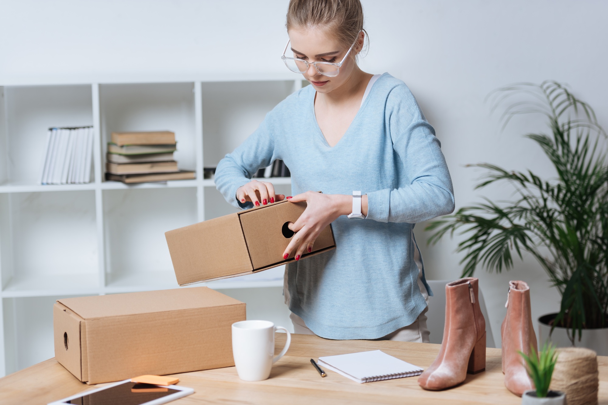 online shop proprietor with cardboard boxes working at home office