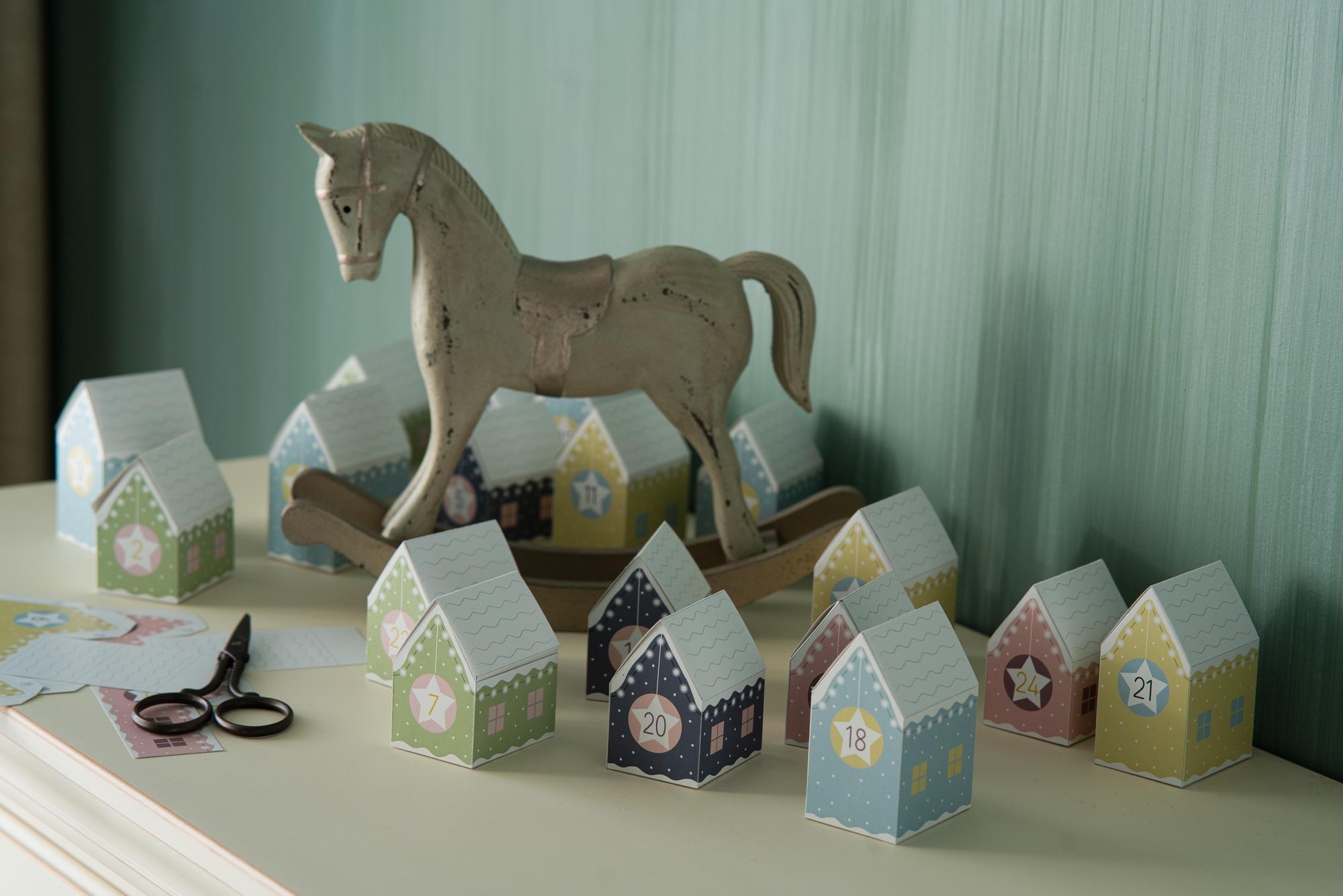 Parer craft advent calendar and wooden Christmas decorations on vintage dresser. DIY Christmas