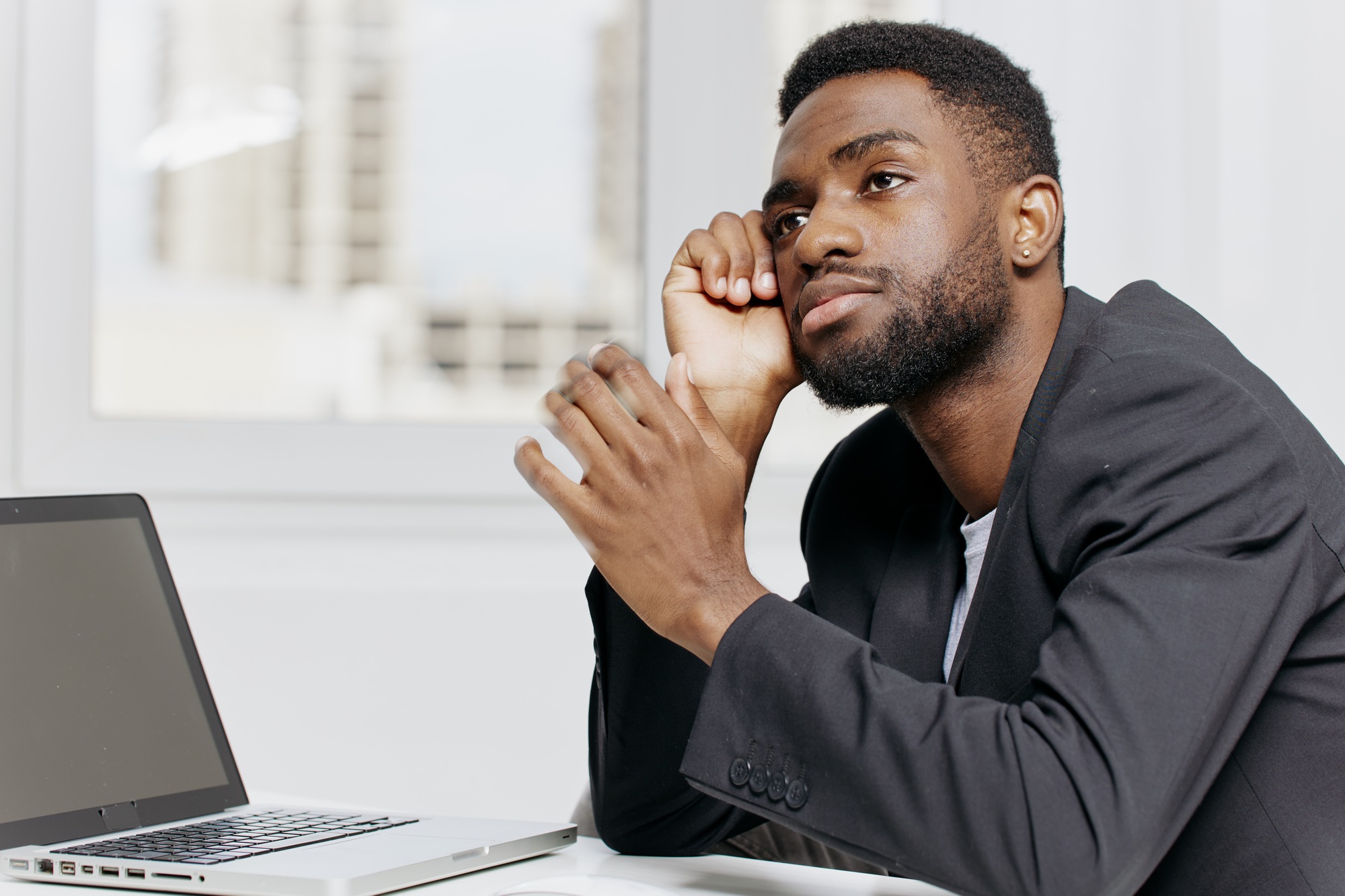 Pensive businessman contemplating strategy while sitting at desk in office environment