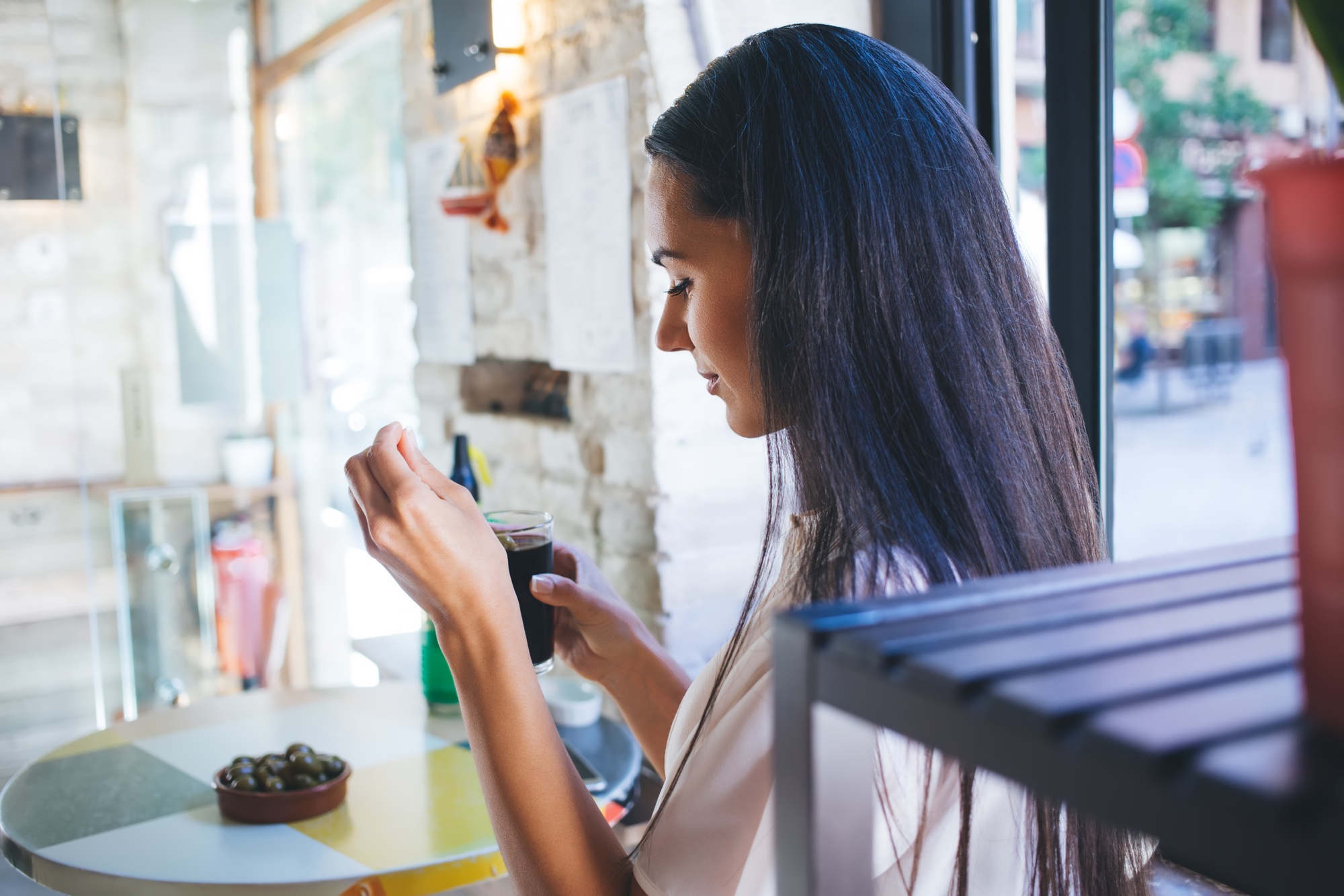 Pondering young female customer with coca cola spending weekend in local cafeteria