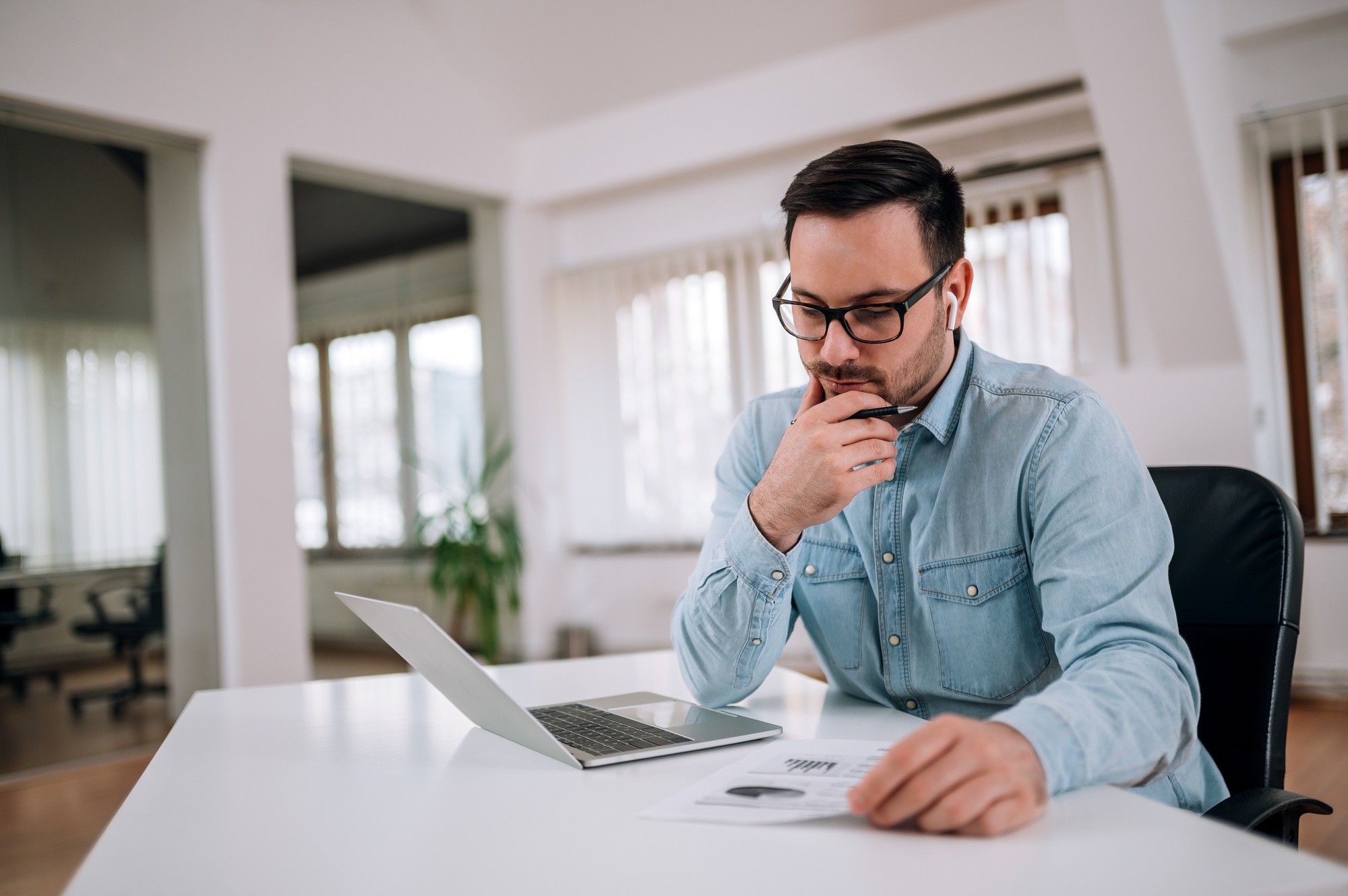 Portrait of a pensive entrepreneur looking at financial report.