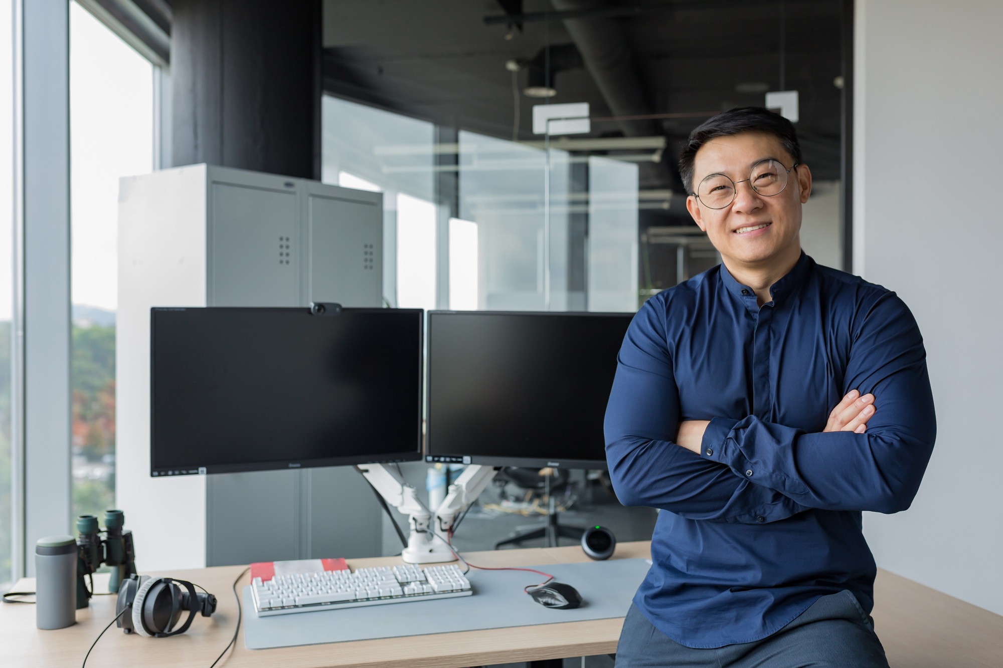 Portrait of successful programmer in modern office of development company, asian man with crossed
