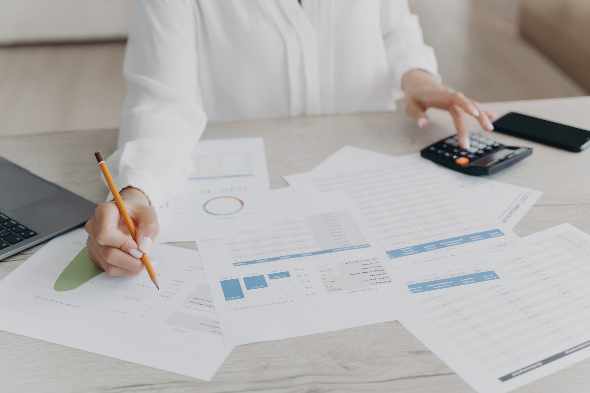 Professional at work analyzing financial data with calculator and documents