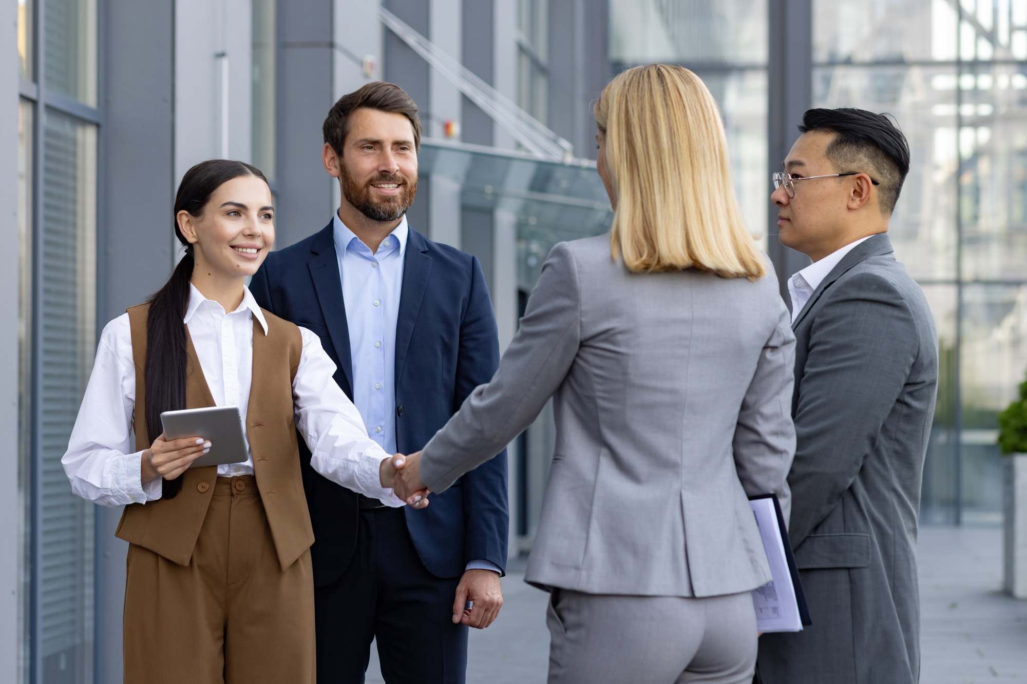 Professional team handshake at modern office building: Collaboration and partnership