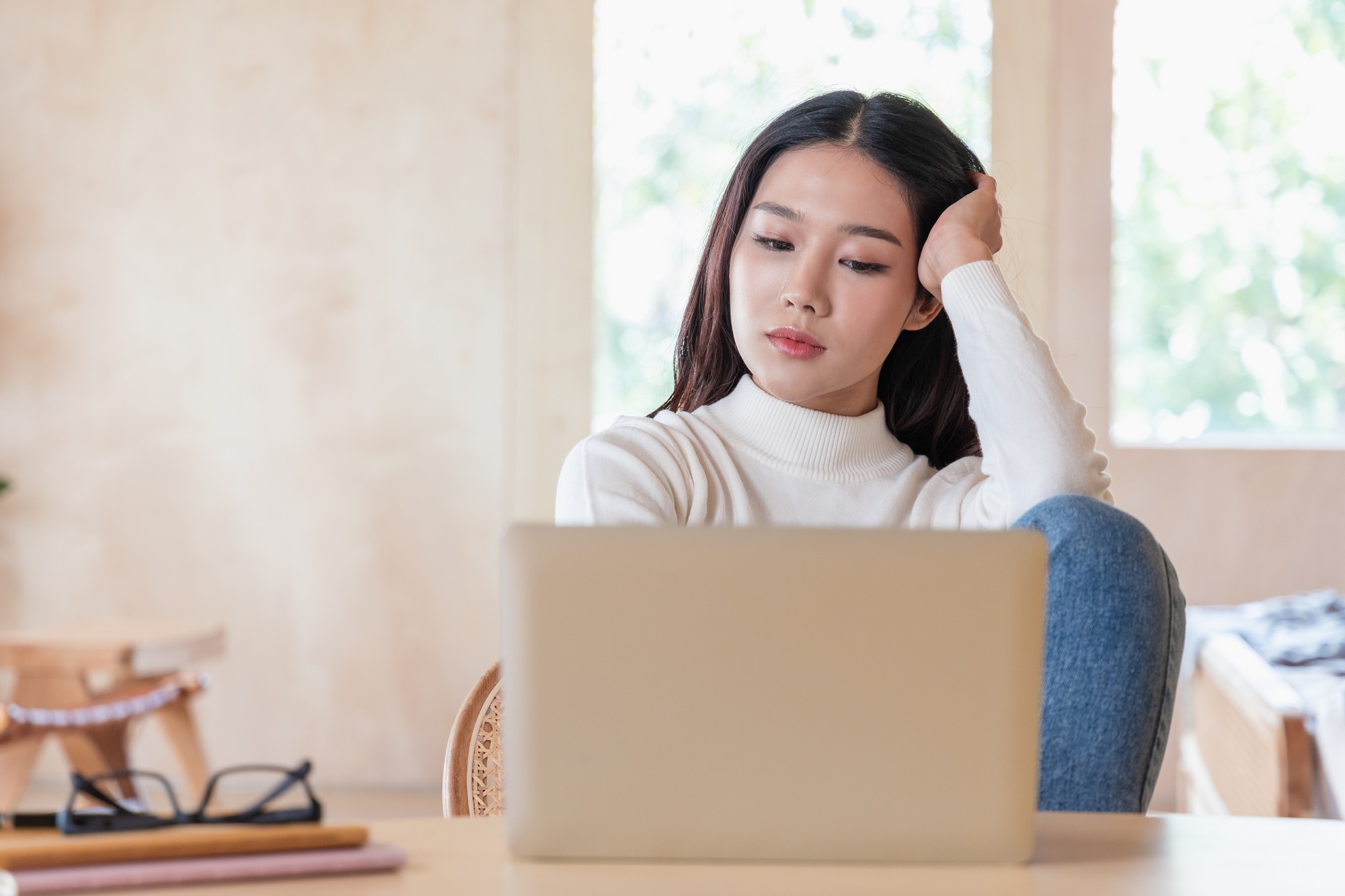 Serious Asian Woman Creating Content on Laptop at Hotel or Home