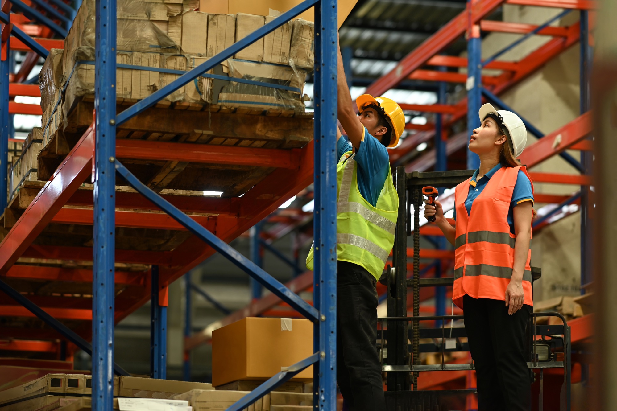Shot of industrial workers checking inventory and quantity of storage product on shelf.