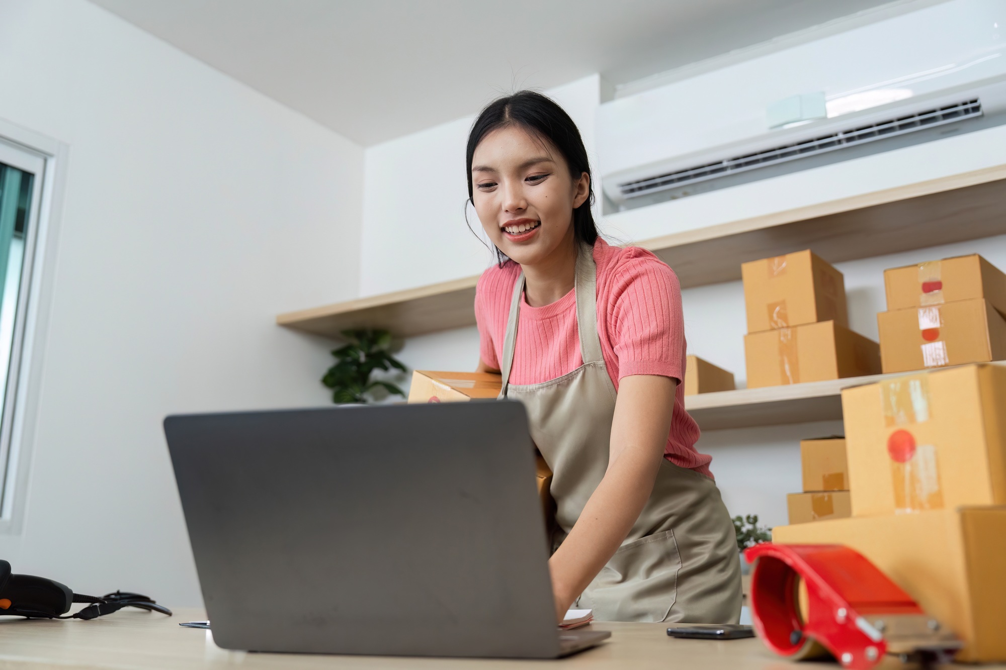 Small Business Operations. Young woman engaging with her laptop in a home office.