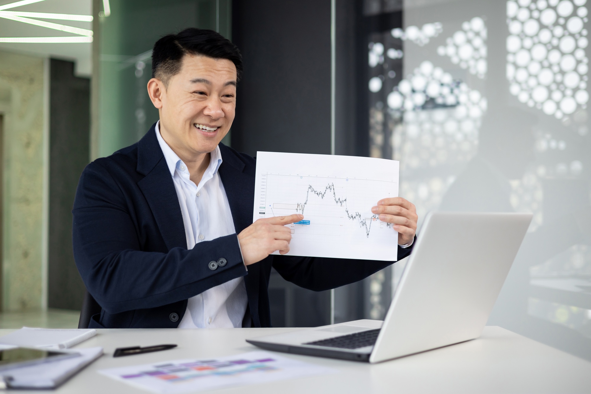 Smiling businessman presenting growth chart in office