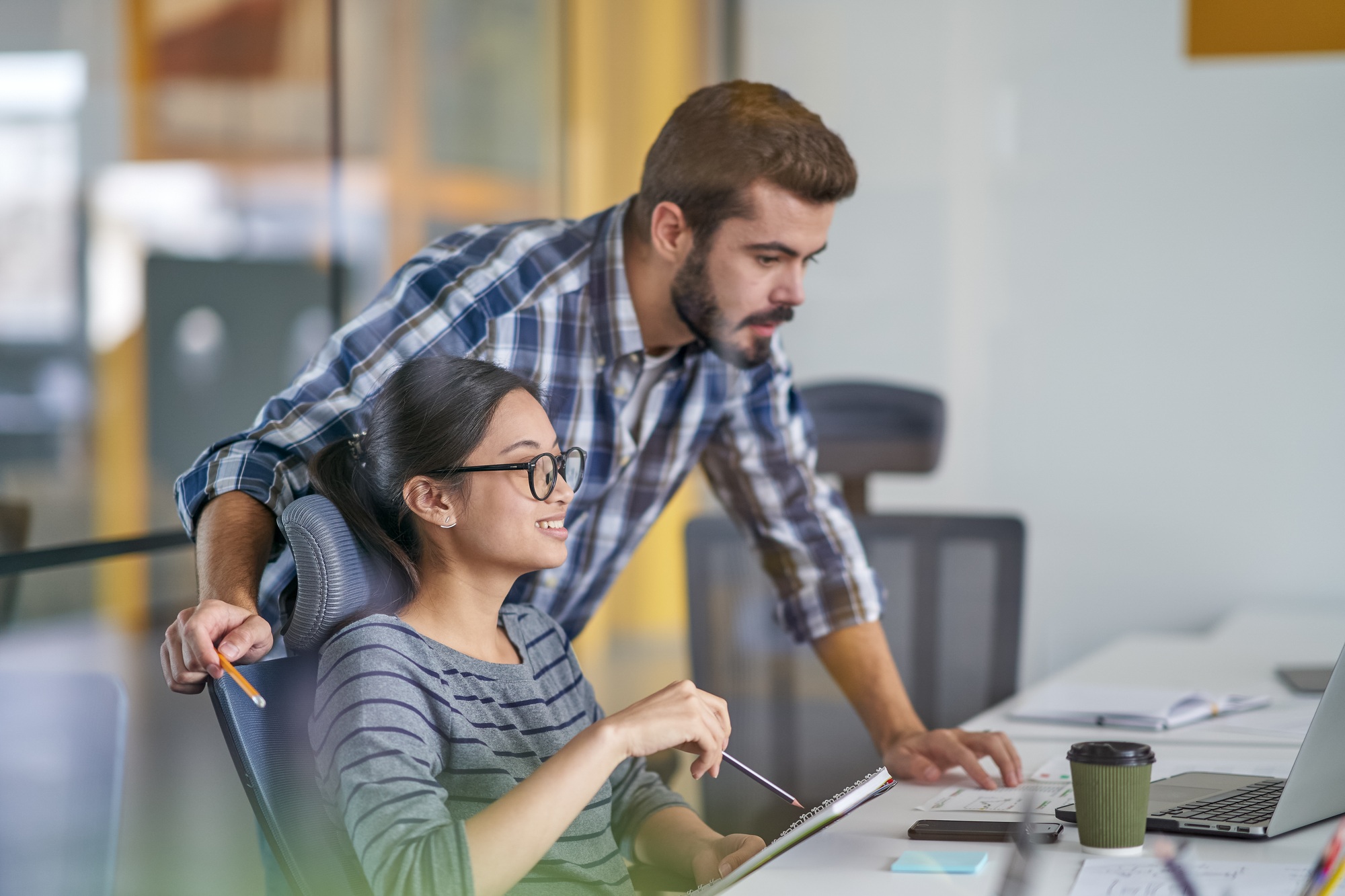 Staff working together on computer in office