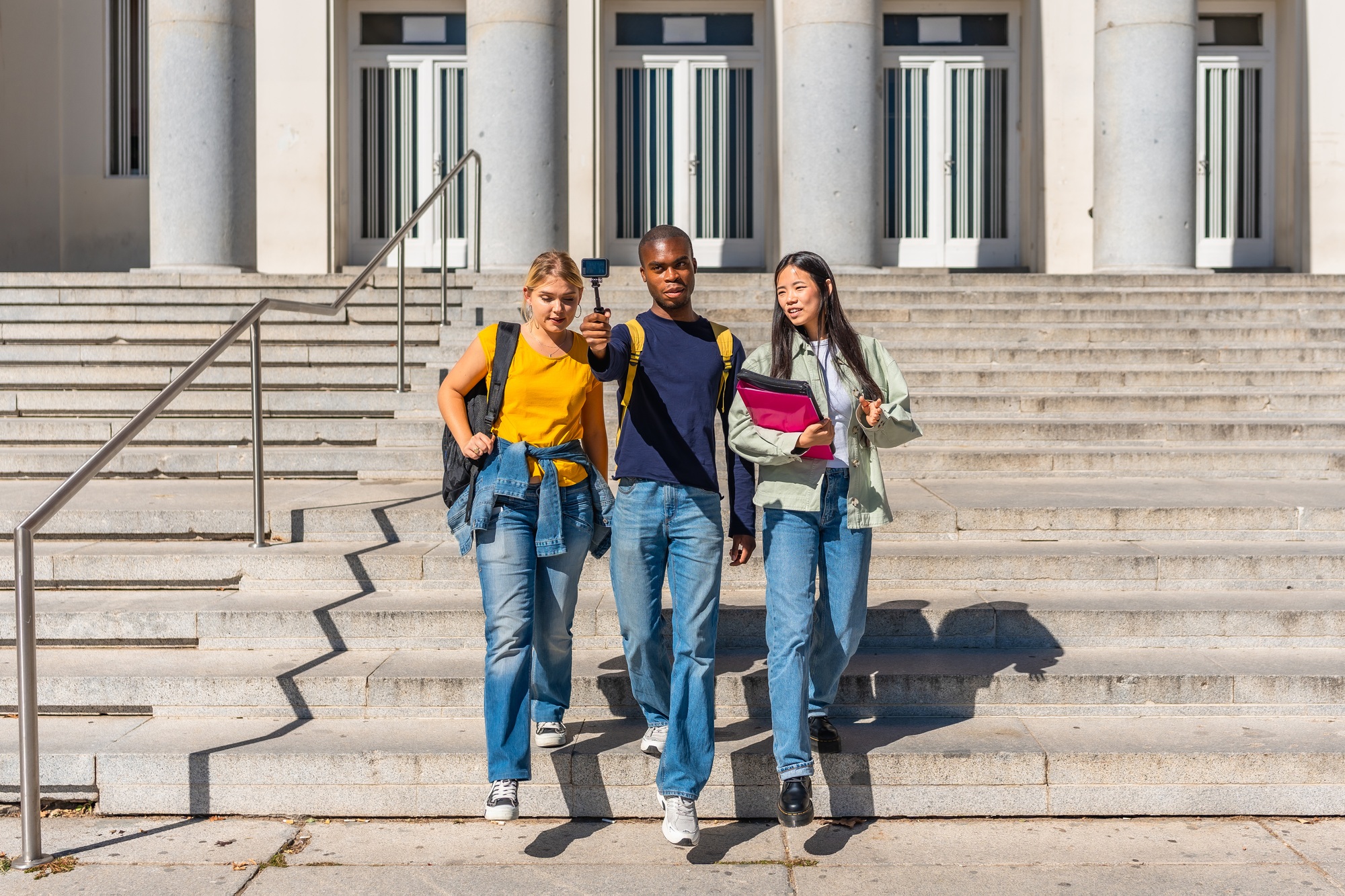 Students walking down stairs recording online video blog