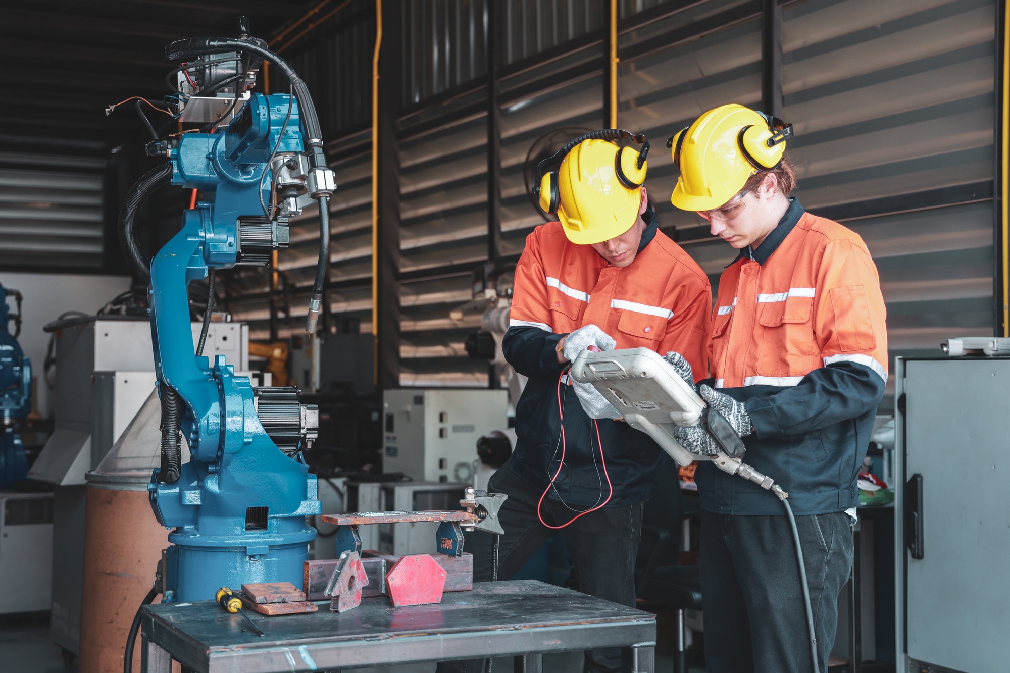 Technicians Programming Industrial Robot Arm