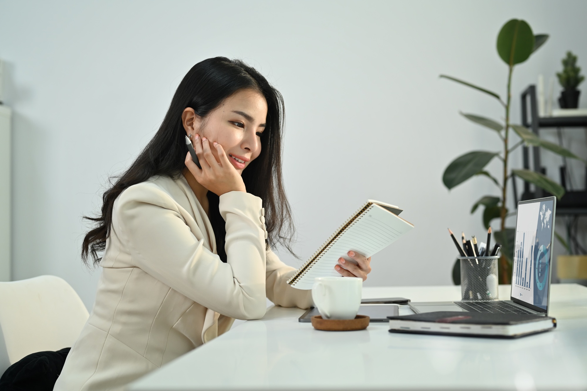 Thoughtful asian woman small business entrepreneur checking working schedule plan in diary.