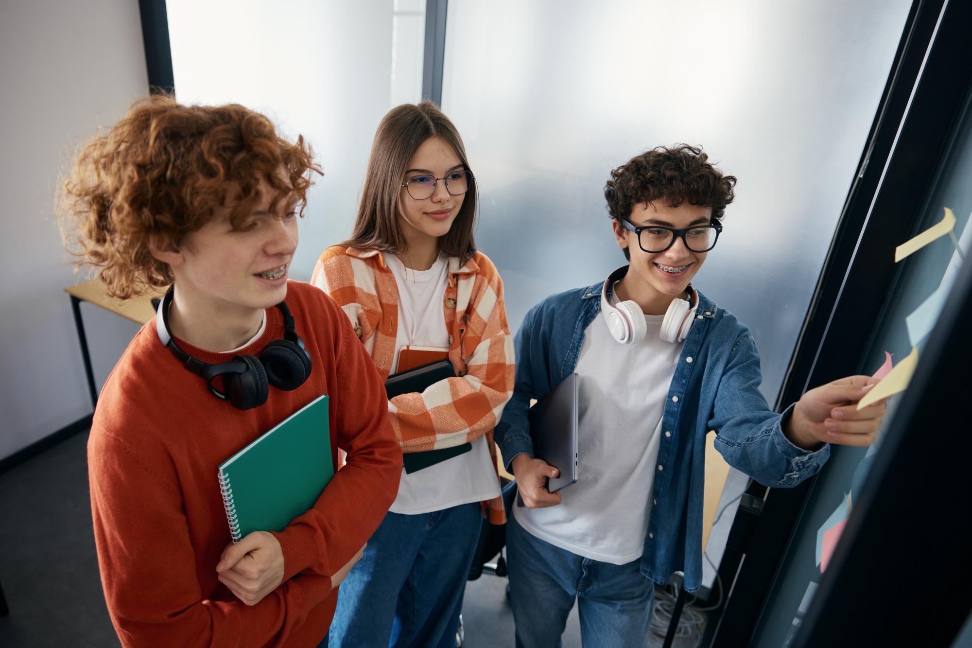 Three teenagers looking at their tasks in office