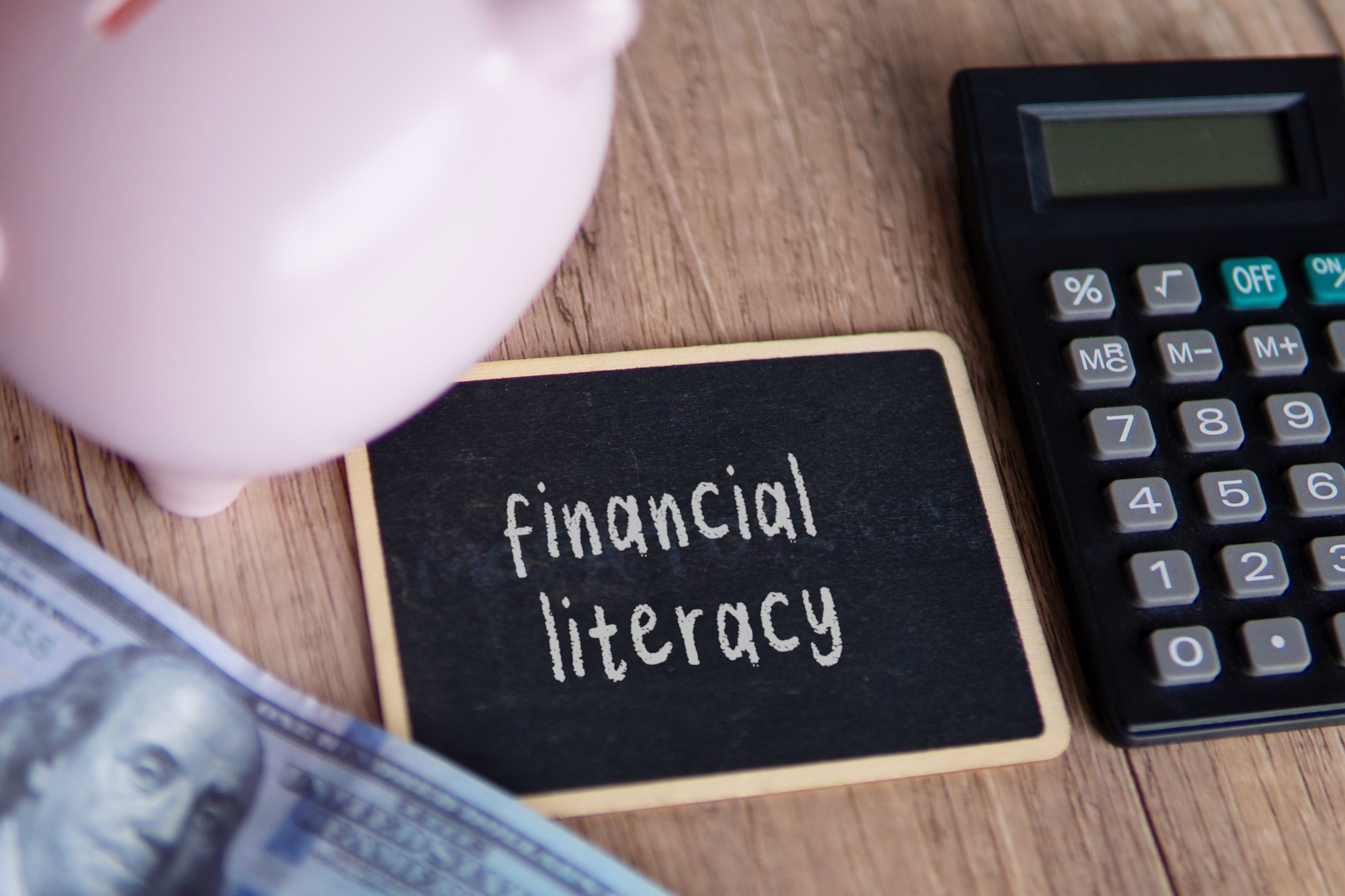 Top view image of piggy bank, calculator and money.