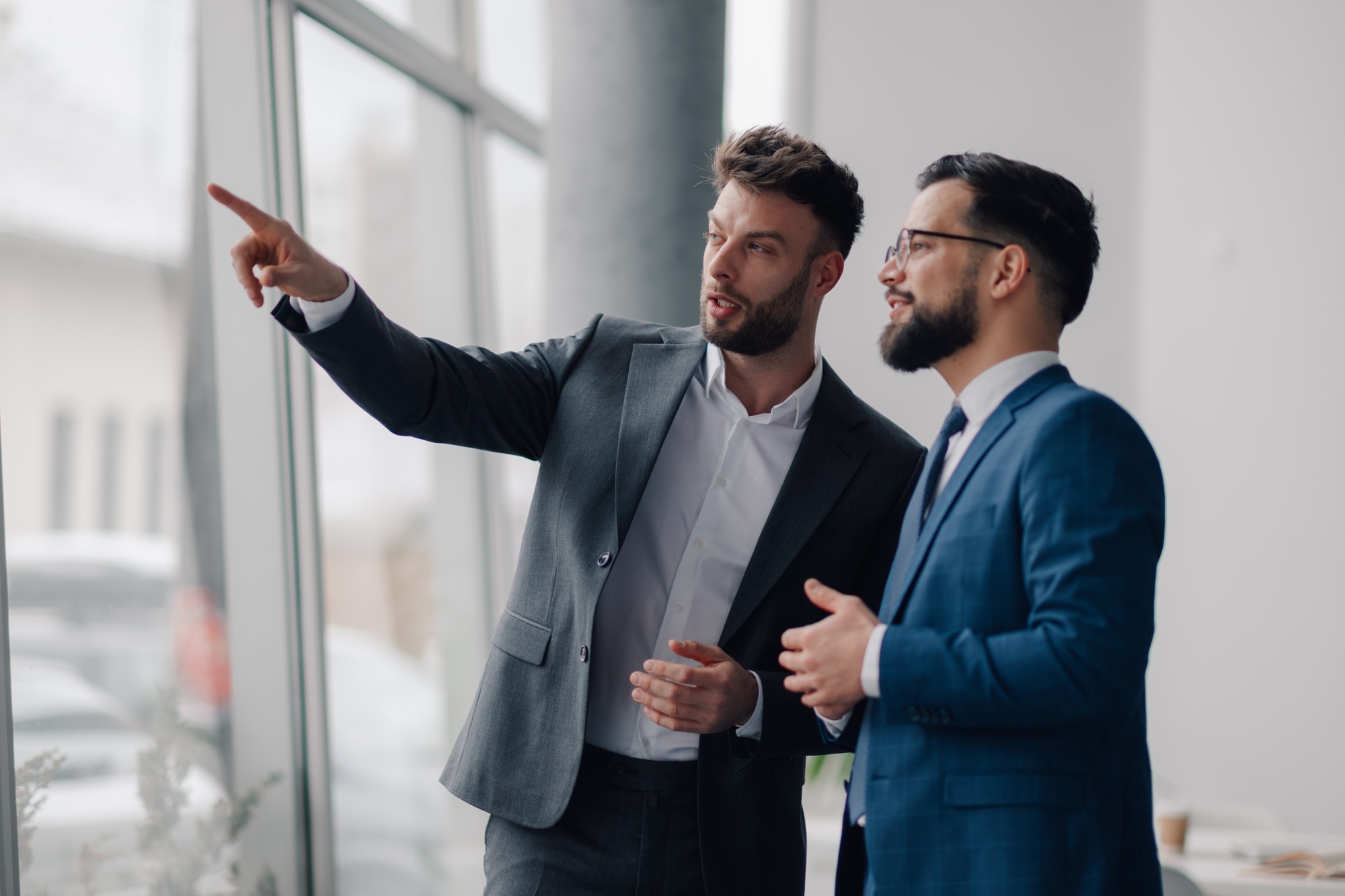 Two businessmen discussing strategy and pointing towards new opportunities