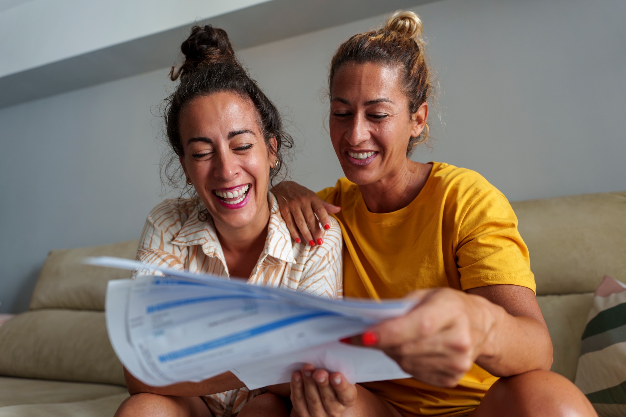 Two Women Couple Reviewing Bills and Financial Documents Together