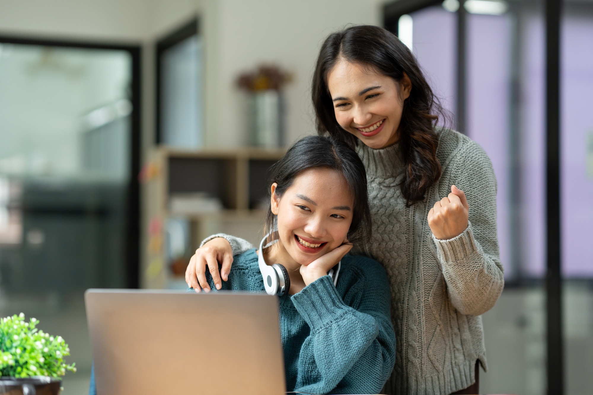 Two young Asian businesswomen discuss with smiles and joy financial management planning. New startup