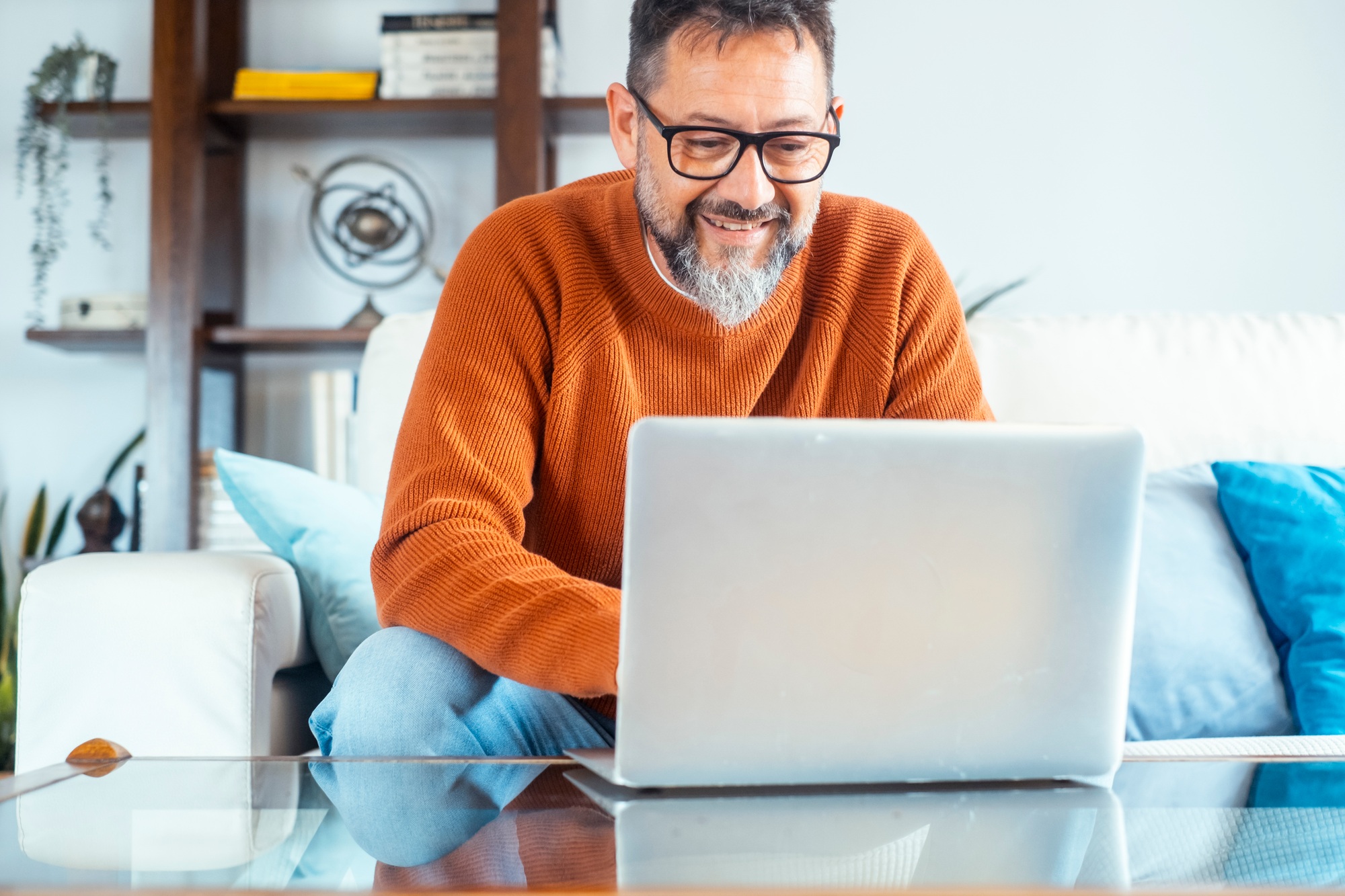 Typing new blog post. Side view of handsome young man using his laptop with smile