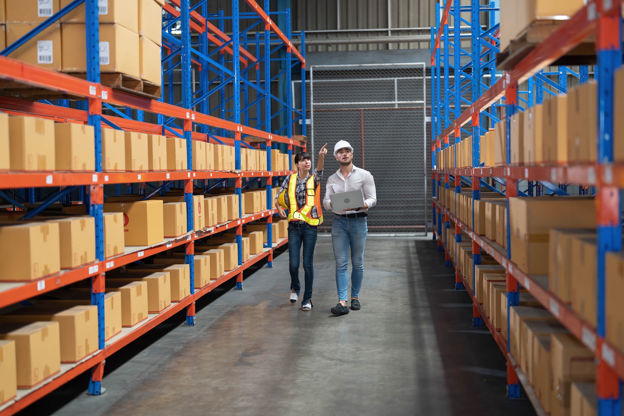 Supervisor and manager hold laptop computer visit warehouse annual audit inventory stock check