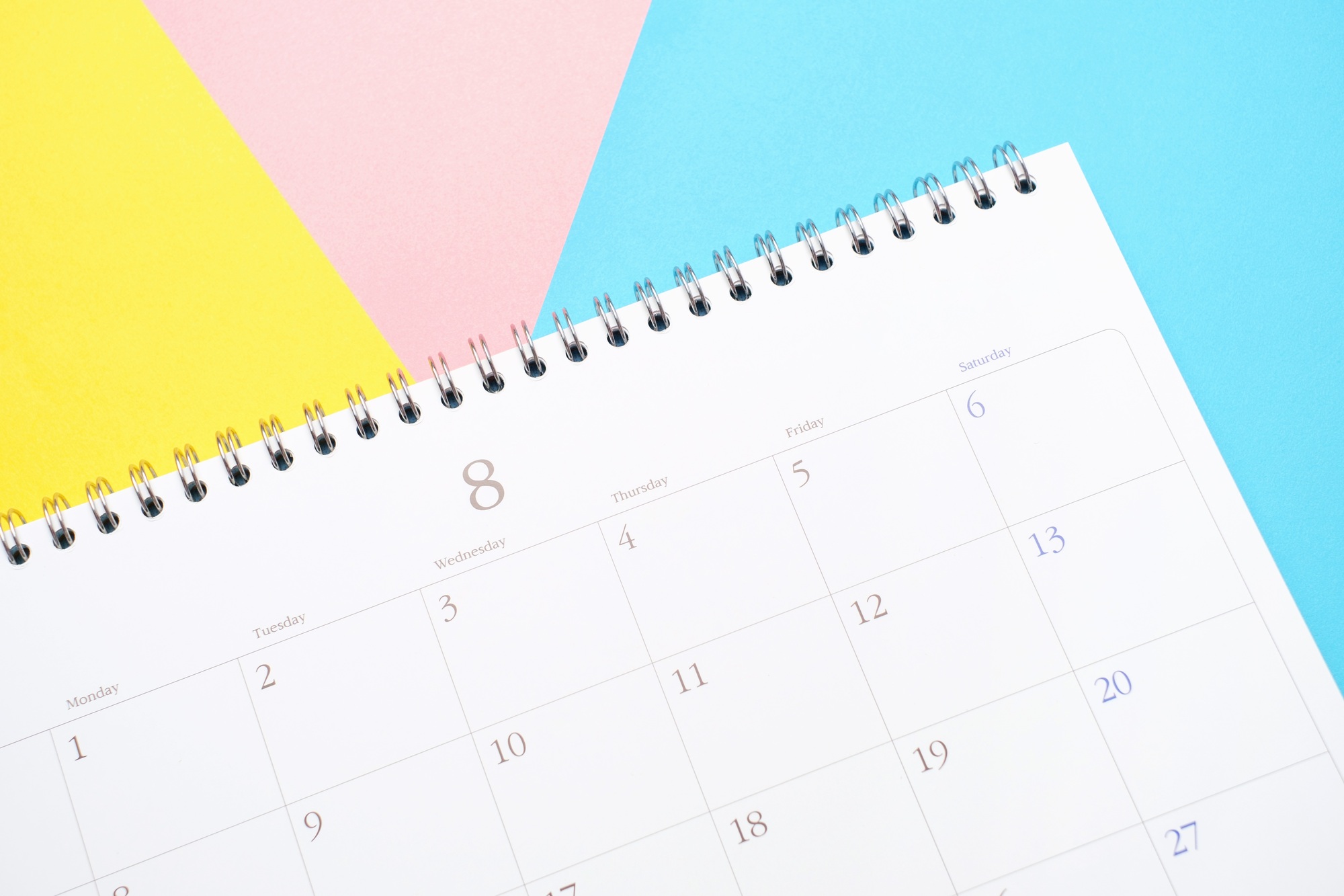 White calendar on colorful background close up, planning concept.