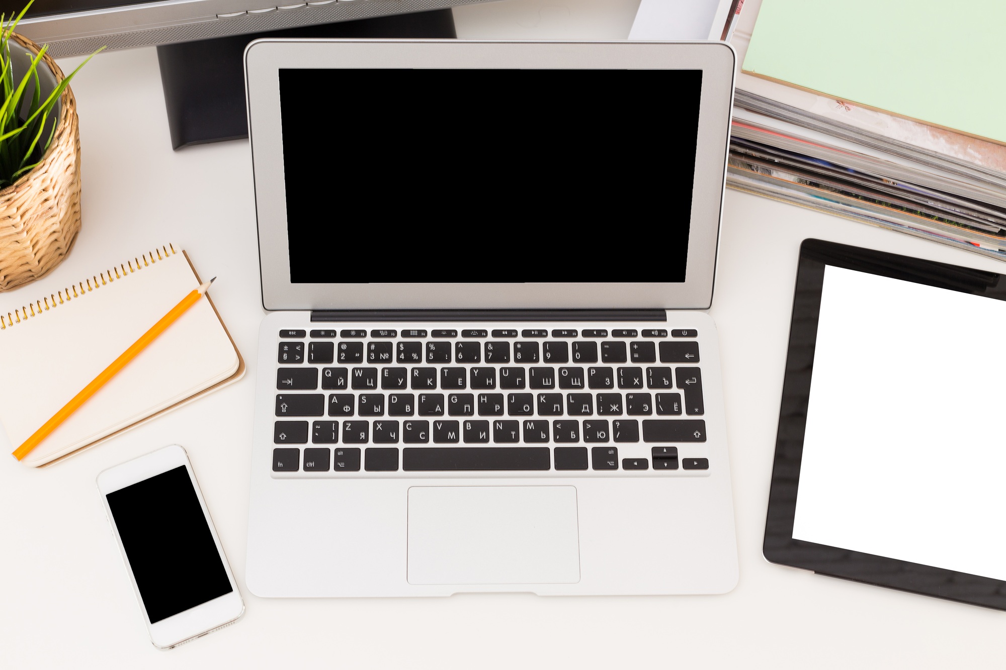Work station overview with laptop, tablet, smartphone, and stationery on a clean desk