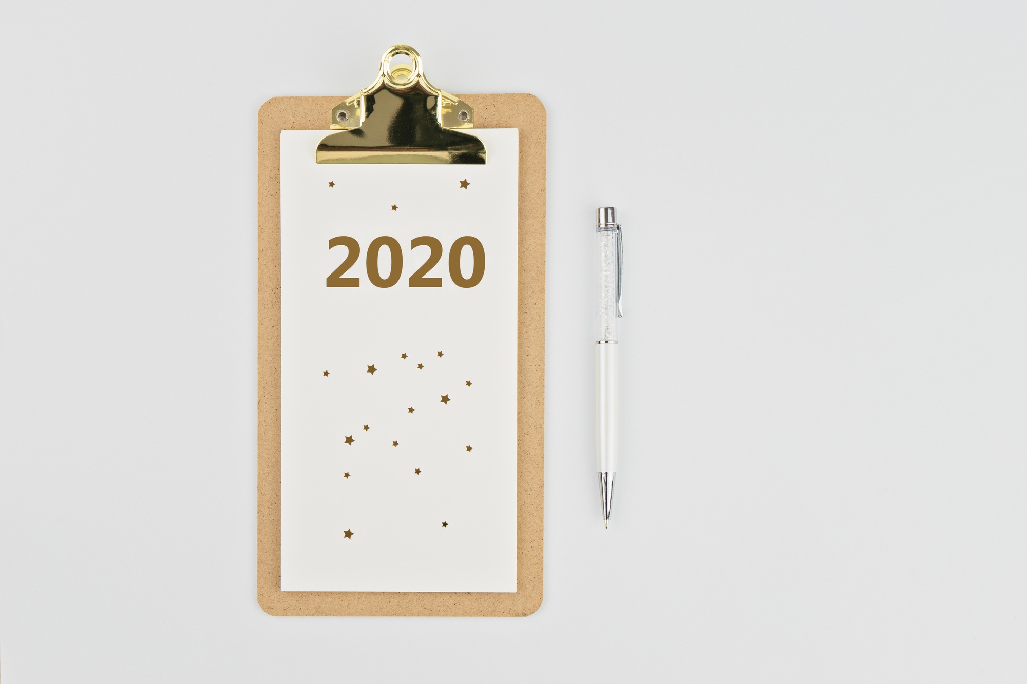 Yearly calendar 2020 clipboard notebook and pen on white background, copy space