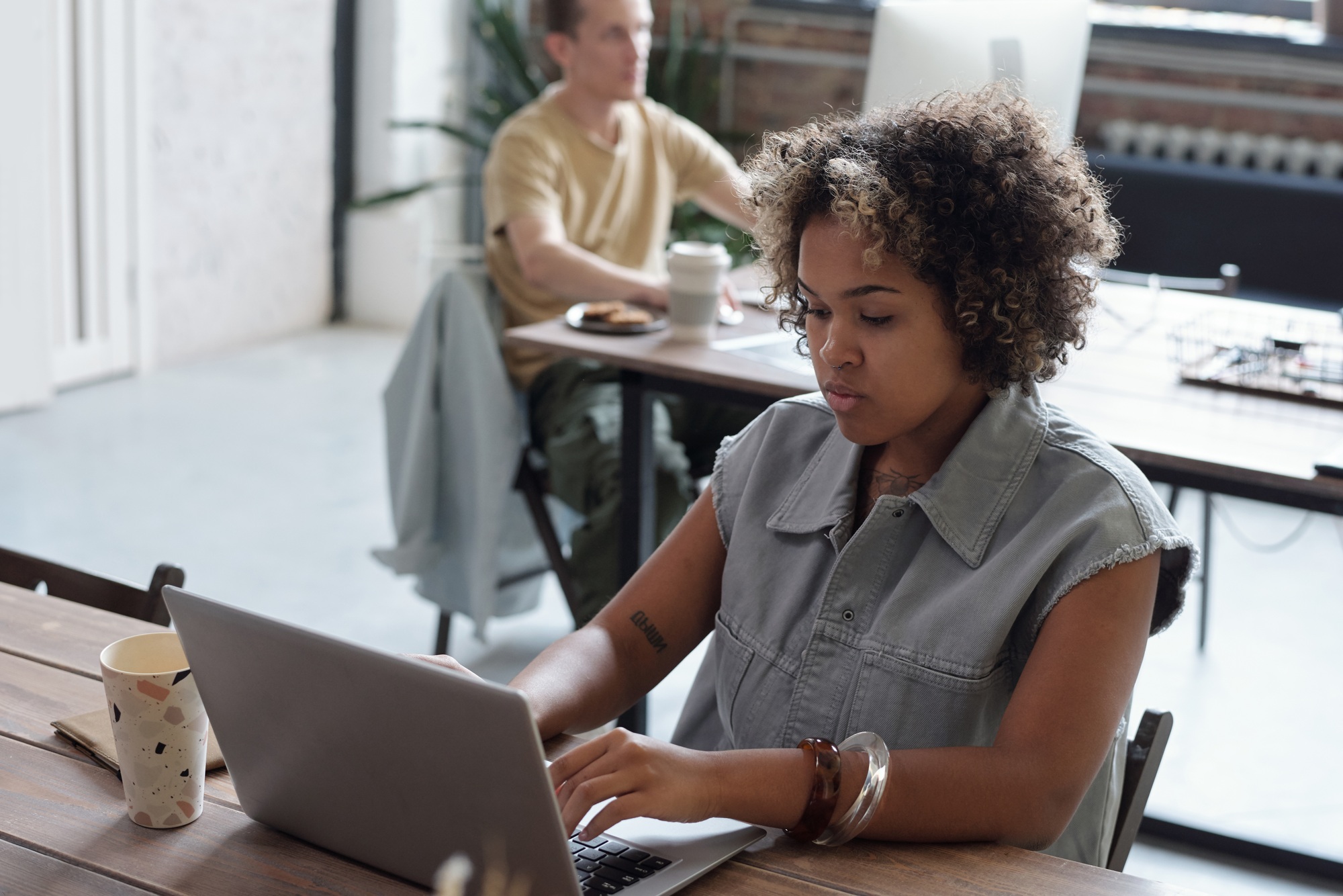 Young biracial businesswoman pressing keys of laptop keypad