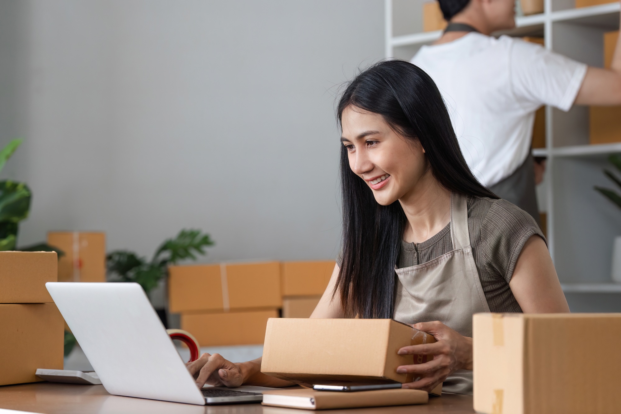 Young Couple Managing Online Business and Checking Product Inventory in Home Office Setting