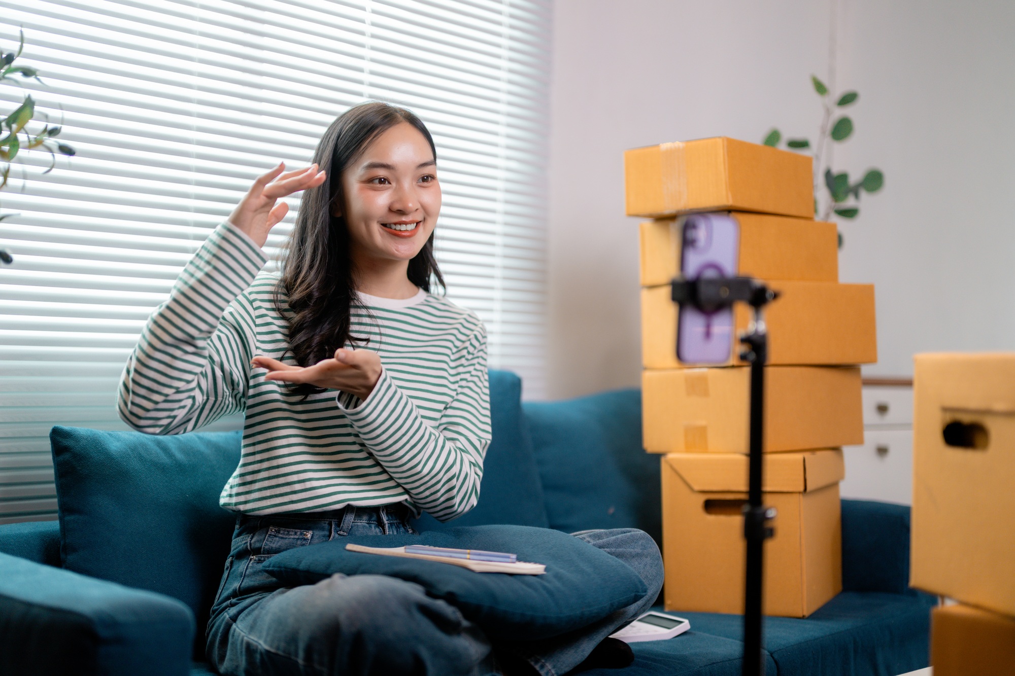 Young entrepreneur presenting products for sale, recording a video blog promoting her small business