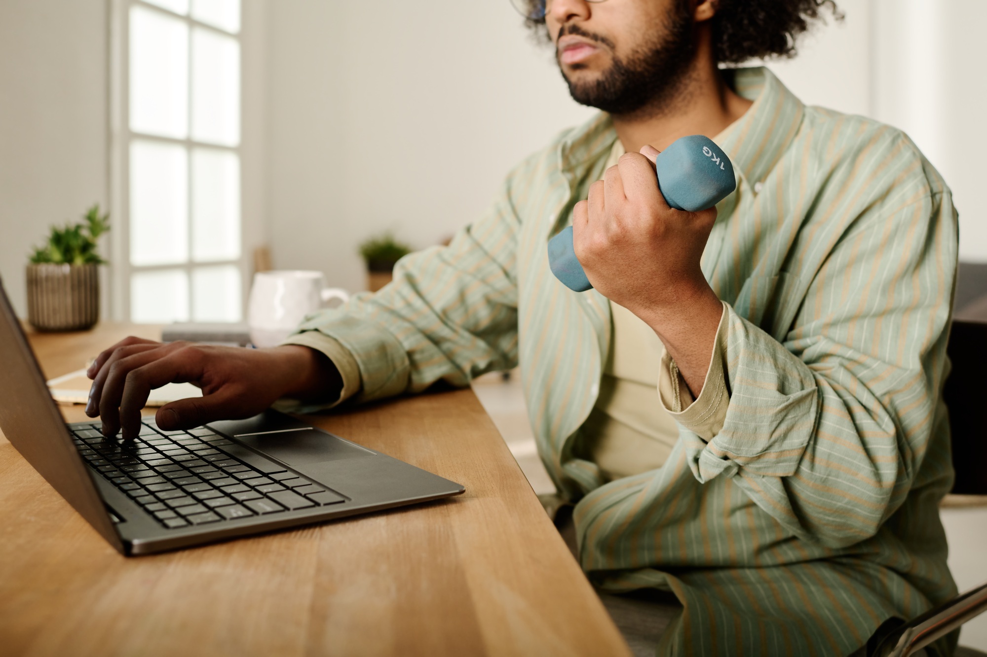 Young male solopreneur with dumbbell