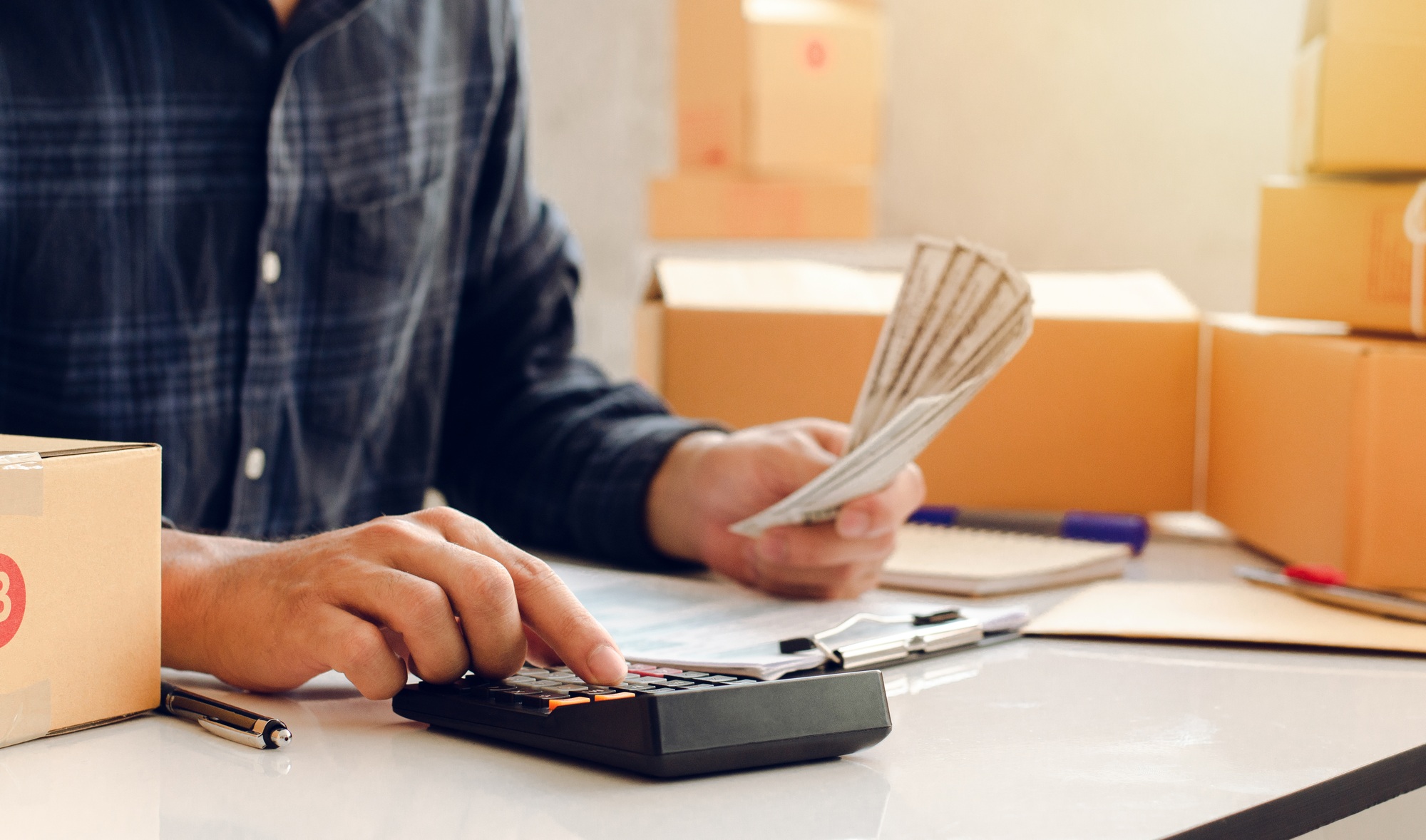 Young man calculating the expenses of his own business