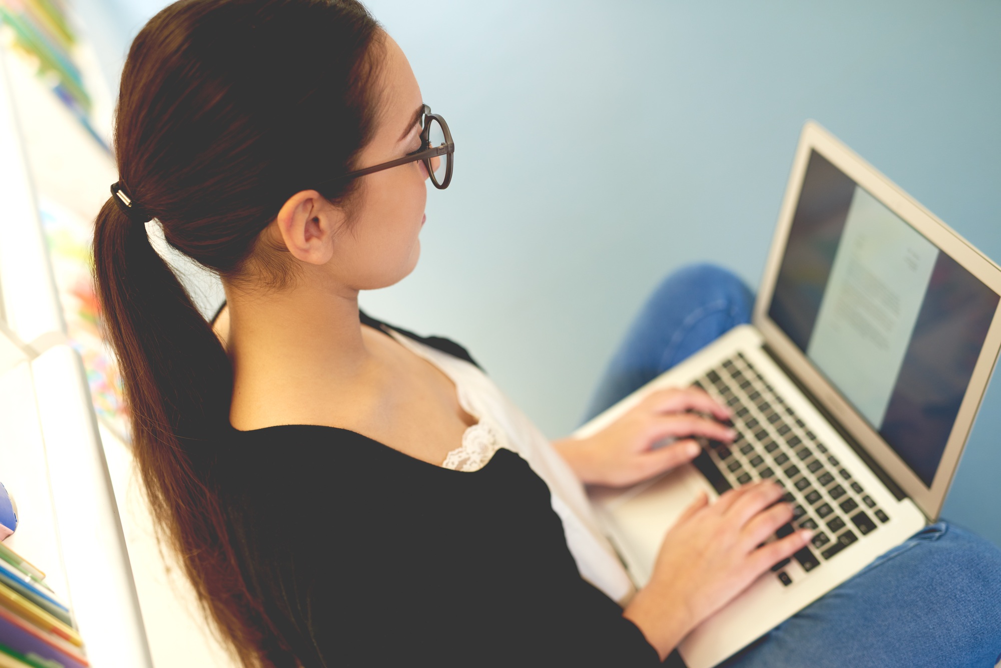 Young woman sitting typing on her laptop